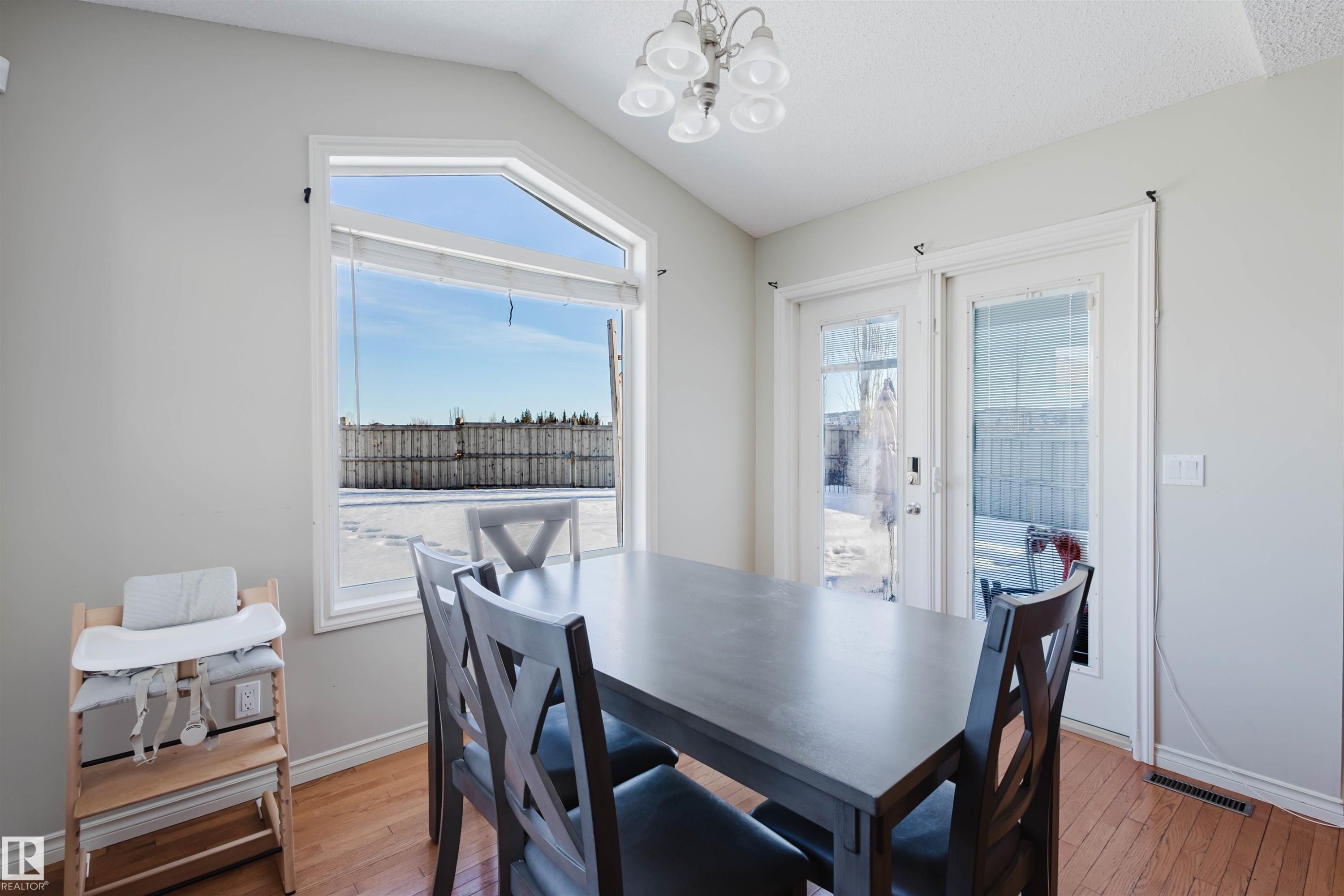 Dining room featuring hanging lights, light wood-type flooring, and lofted ceiling - 3534 Mclean Crescent, Edmonton, AB - Indoor Photo Showing Dining Room