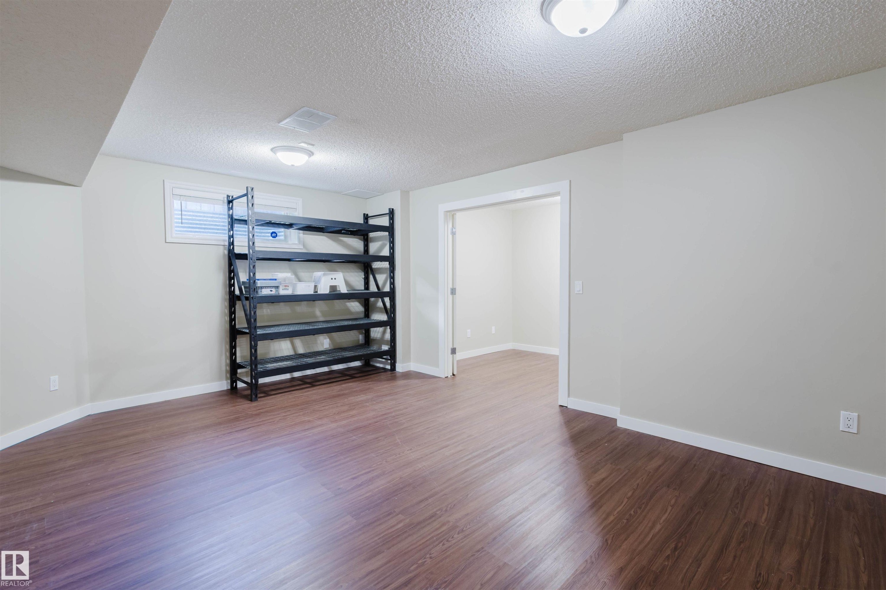 Below grade area featuring a textured ceiling and dark wood finished floors - 3534 Mclean Crescent, Edmonton, AB - Indoor