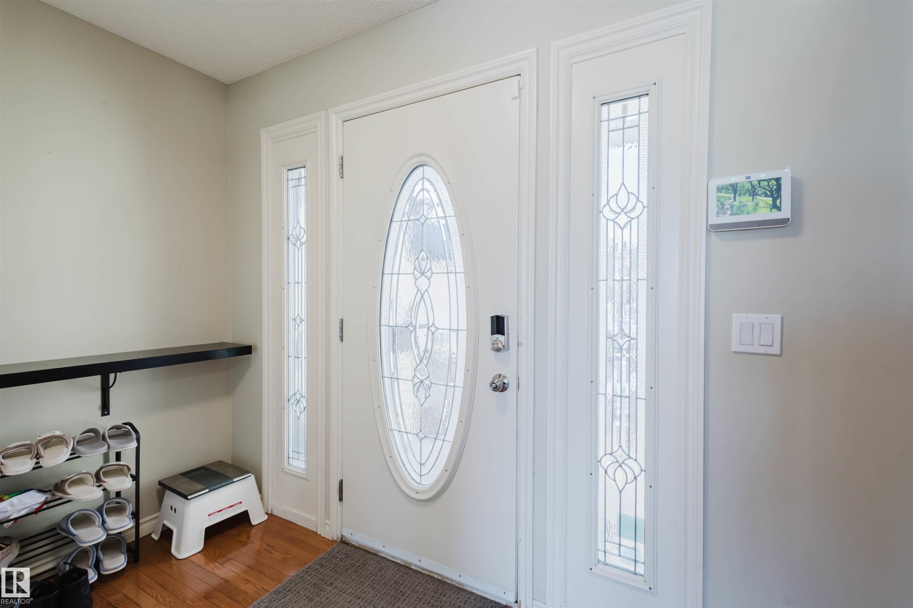 Foyer with dark wood finished floors and healthy amount of natural light - 3534 Mclean Crescent, Edmonton, AB - Indoor