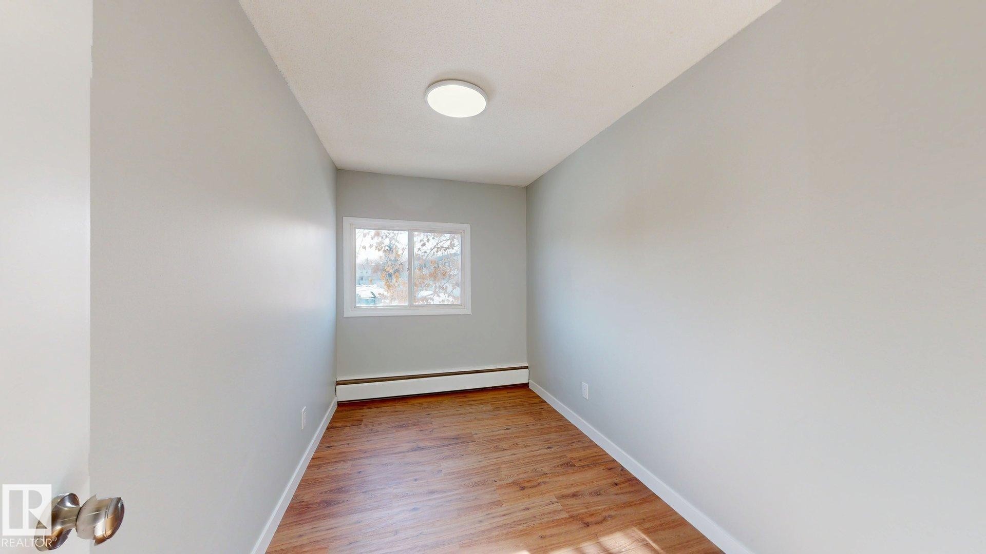 Unfurnished room with light wood-style flooring and baseboard heating - 611 2908 116A Avenue, Edmonton, AB - Indoor Photo Showing Other Room