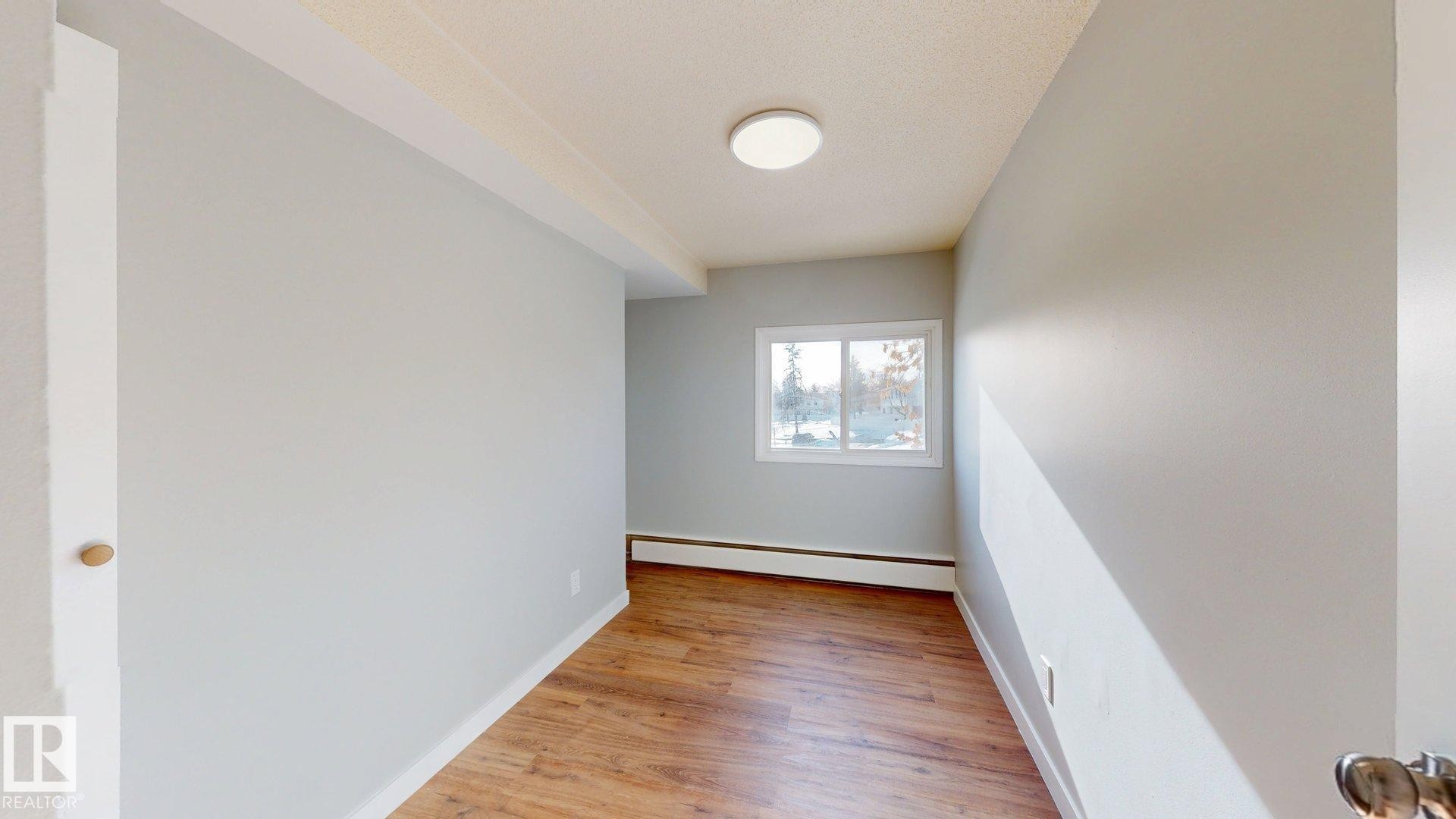 Spare room with light wood-style floors and baseboard heating - 611 2908 116A Avenue, Edmonton, AB - Indoor Photo Showing Other Room