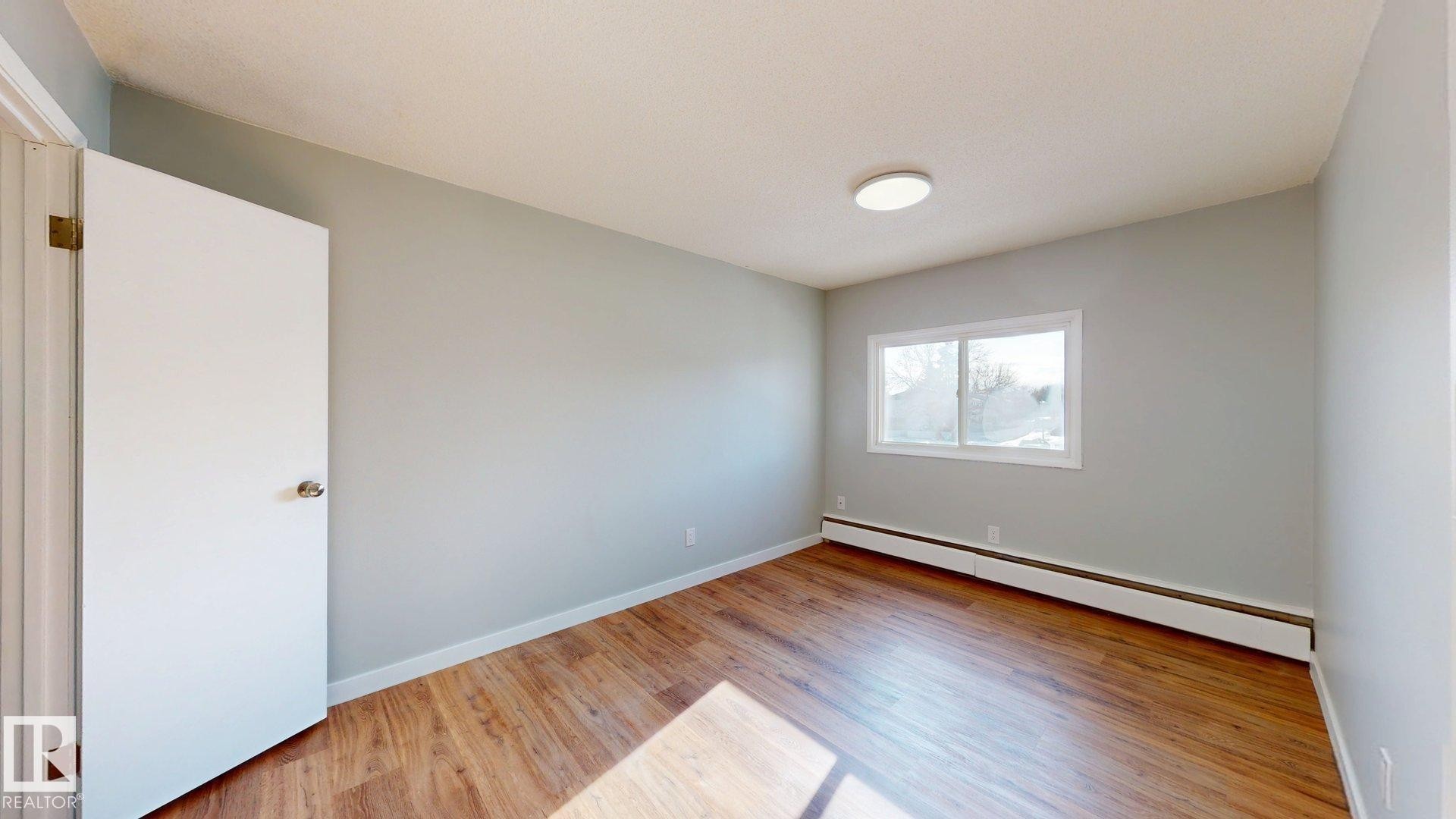 Spare room with light wood finished floors and baseboard heating - 611 2908 116A Avenue, Edmonton, AB - Indoor Photo Showing Other Room