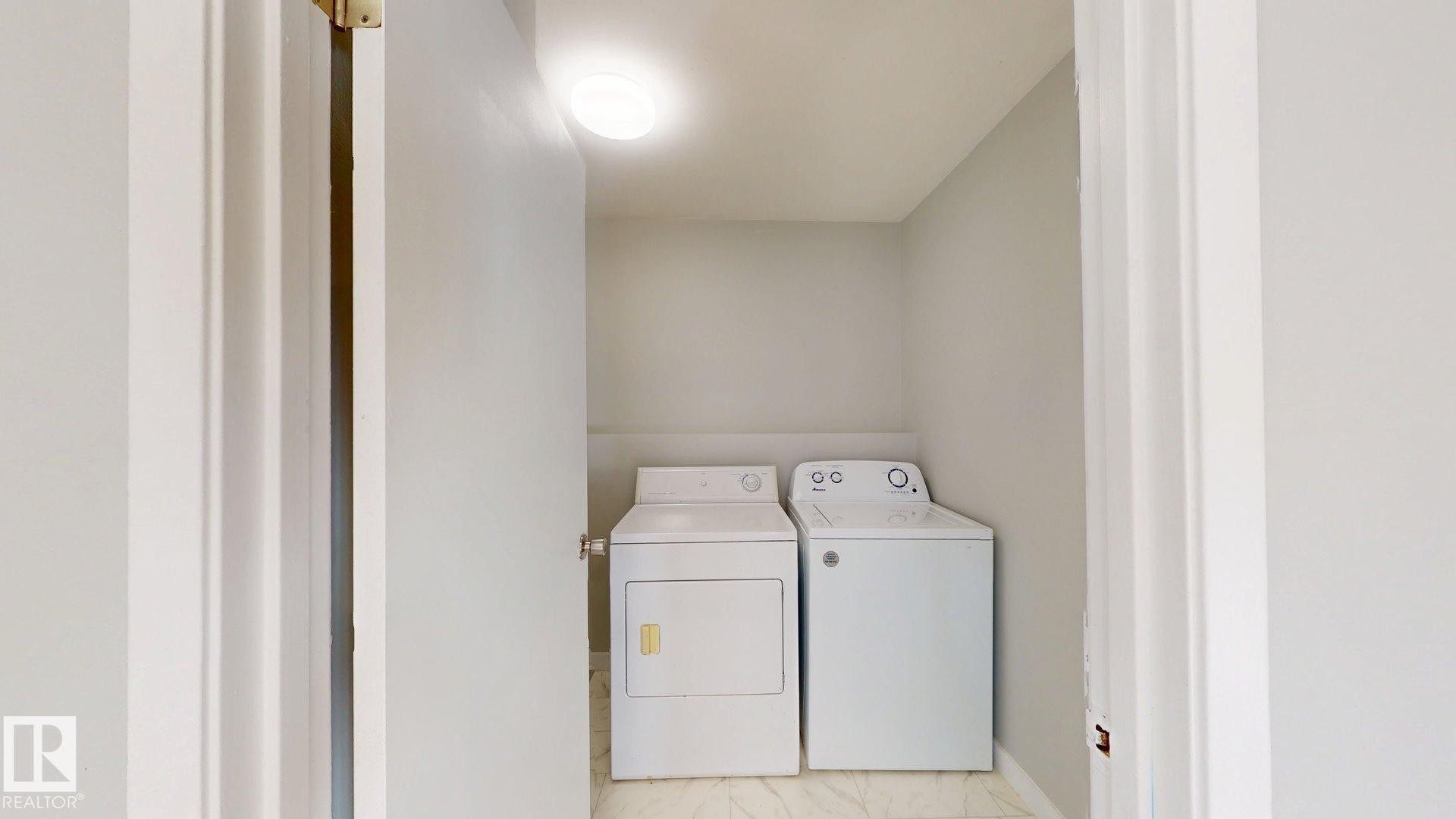 Laundry room with separate washer and dryer and baseboards - 611 2908 116A Avenue, Edmonton, AB - Indoor Photo Showing Laundry Room