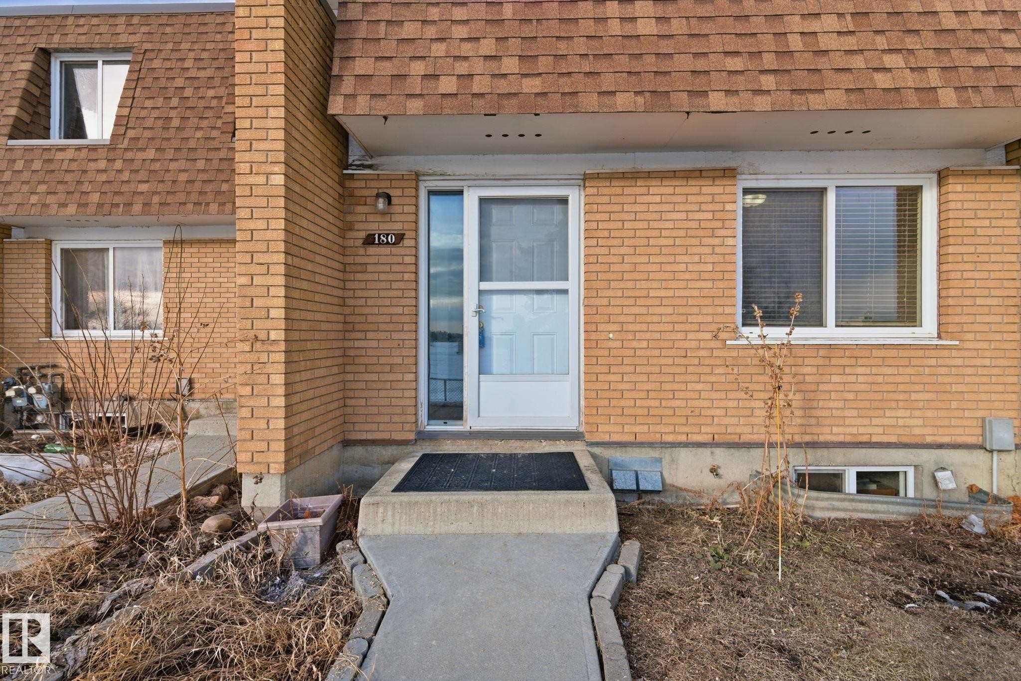 Entrance to property featuring brick siding, a shingled roof, and mansard roof - 180 Londonderry Square, Edmonton, AB - Outdoor With Exterior