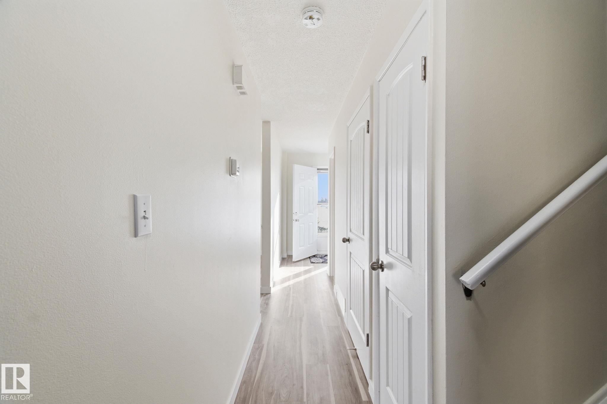 Hall with light wood-style floors and a textured ceiling - 180 Londonderry Square, Edmonton, AB - Indoor Photo Showing Other Room