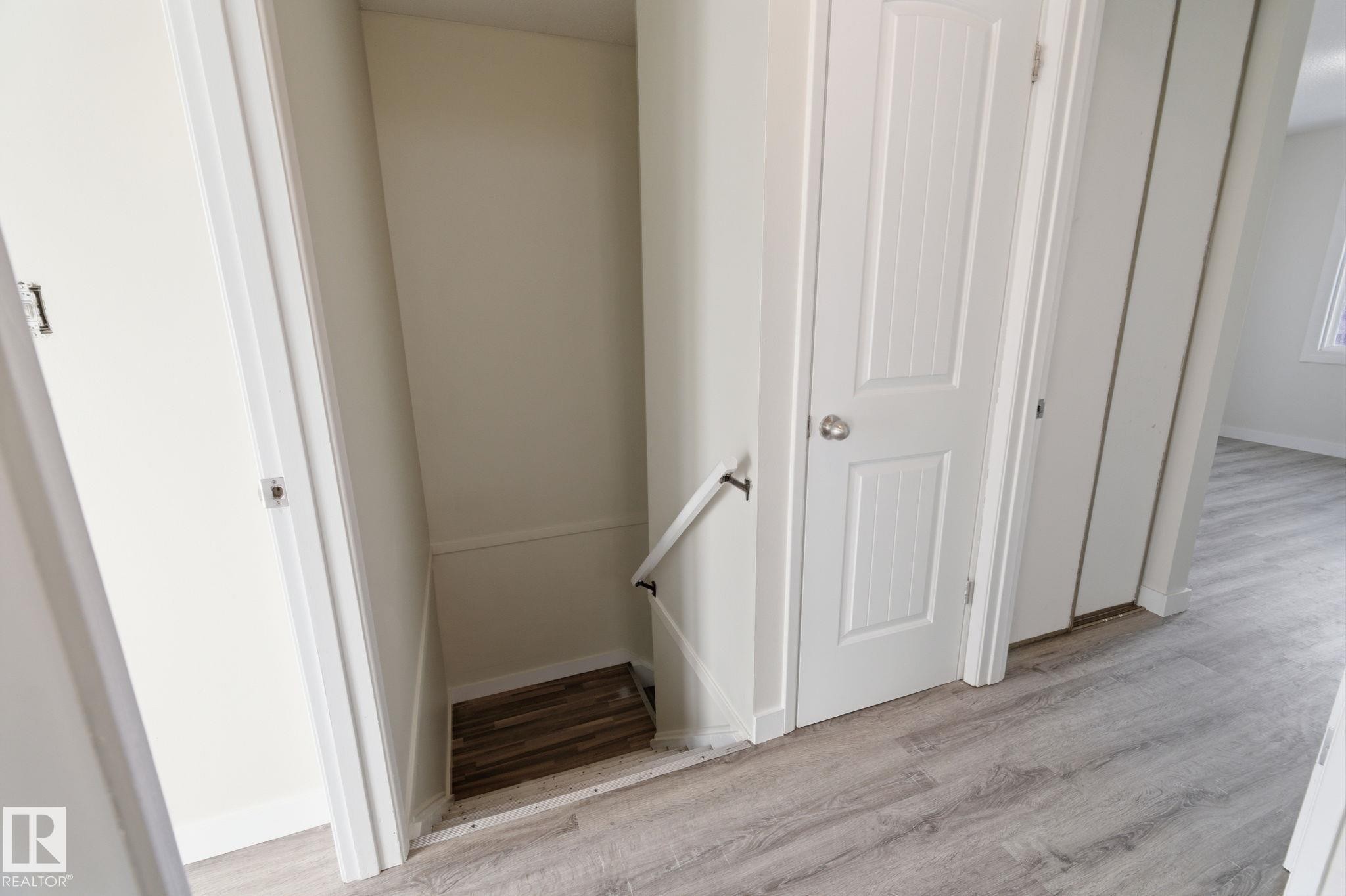 Stairs featuring wood finished floors and baseboards - 180 Londonderry Square, Edmonton, AB - Indoor Photo Showing Other Room