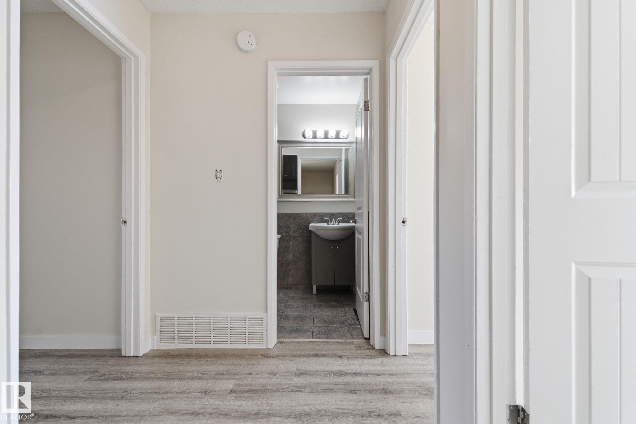 Hallway featuring light wood-style flooring and a sink - 180 Londonderry Square, Edmonton, AB - Indoor Photo Showing Other Room