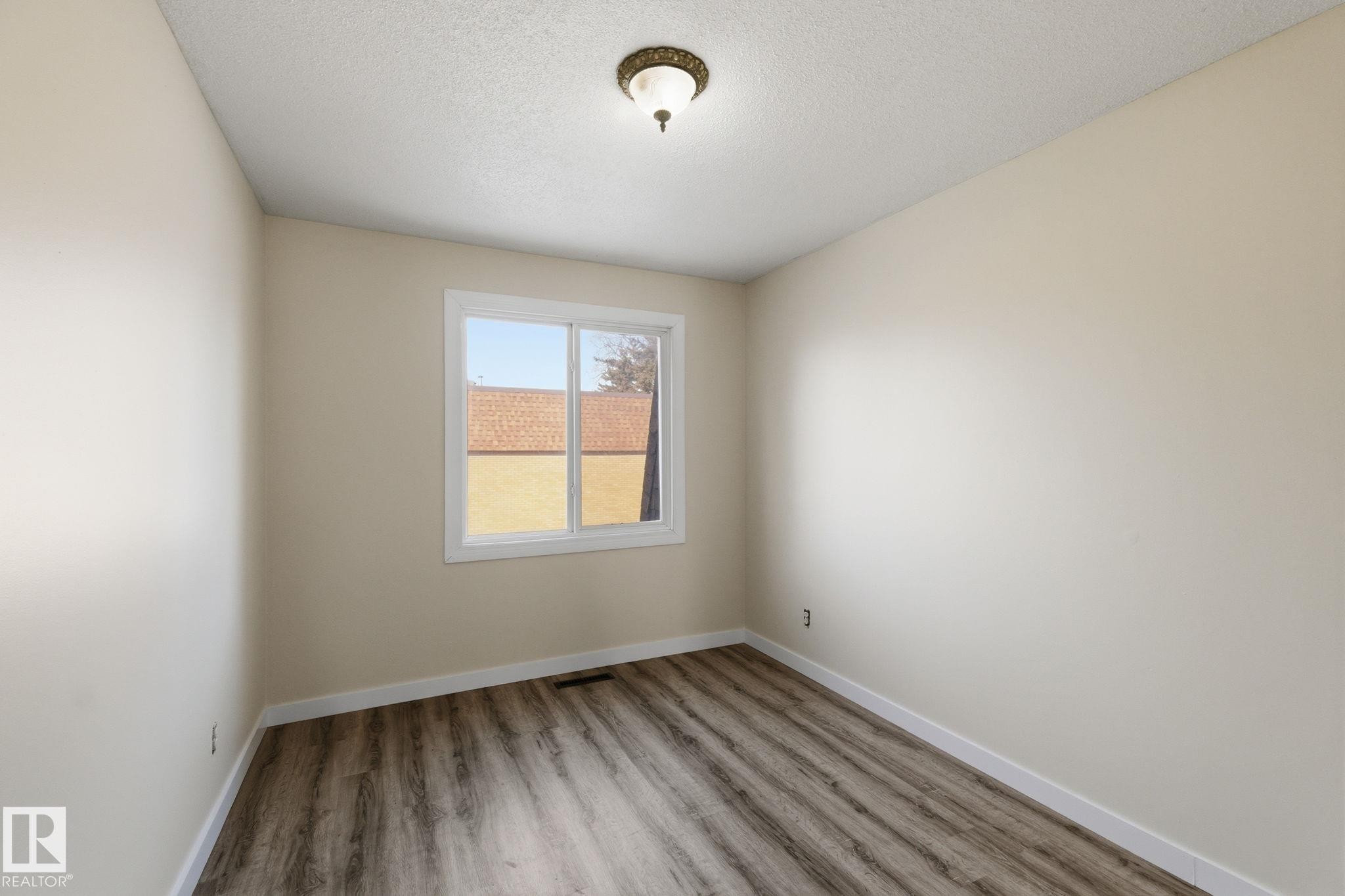 Unfurnished room featuring light wood-type flooring and a textured ceiling - 180 Londonderry Square, Edmonton, AB - Indoor Photo Showing Other Room