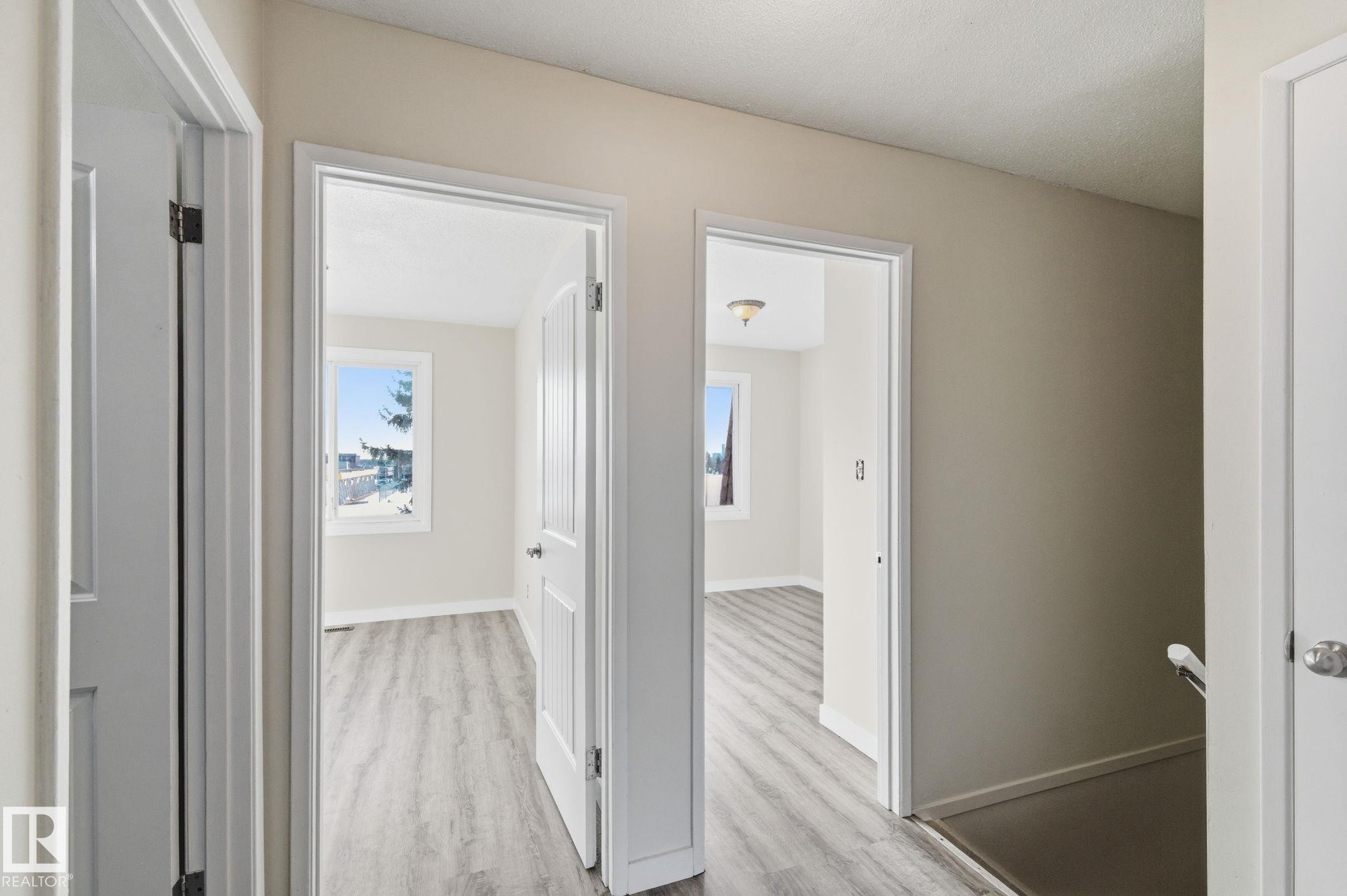 Hall with baseboards and light wood-style flooring - 180 Londonderry Square, Edmonton, AB - Indoor Photo Showing Other Room