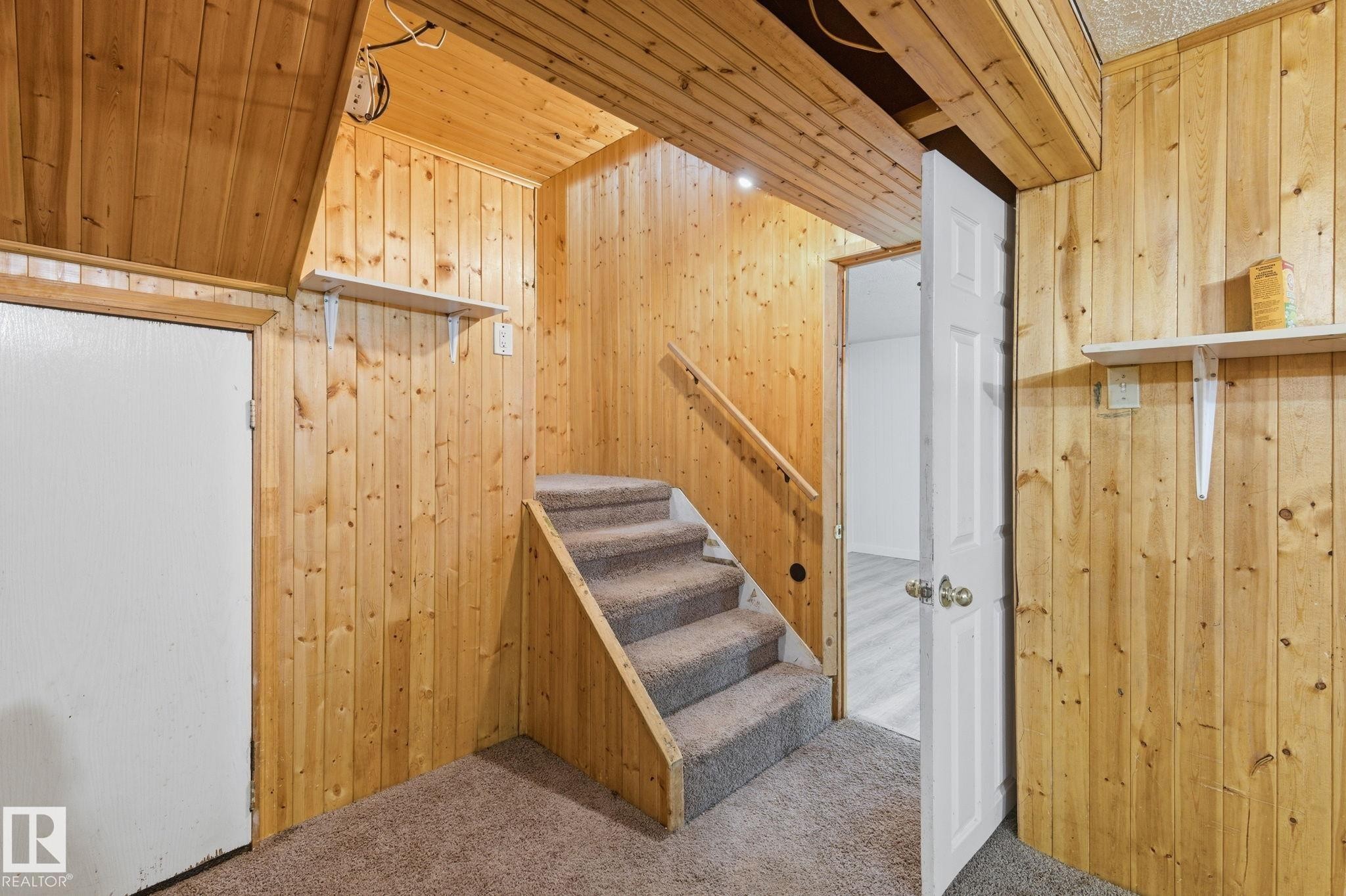 Staircase with wood walls and carpet flooring - 180 Londonderry Square, Edmonton, AB - Indoor Photo Showing Other Room