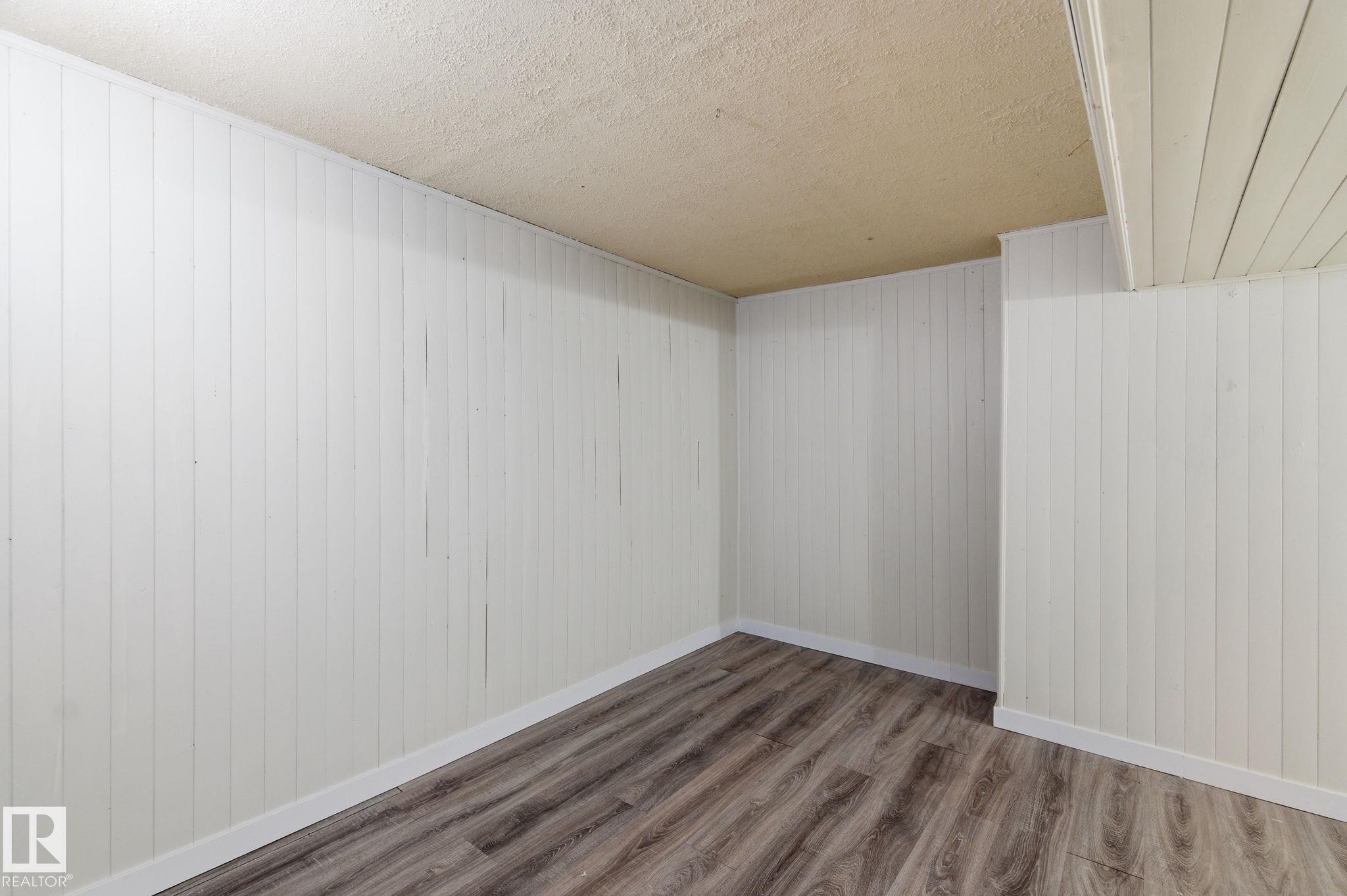 Empty room with wood finished floors and a textured ceiling - 180 Londonderry Square, Edmonton, AB - Indoor Photo Showing Other Room