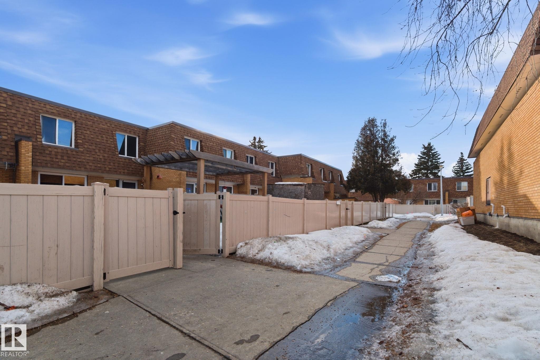 Snowy yard featuring a gate and a residential view - 180 Londonderry Square, Edmonton, AB - Outdoor