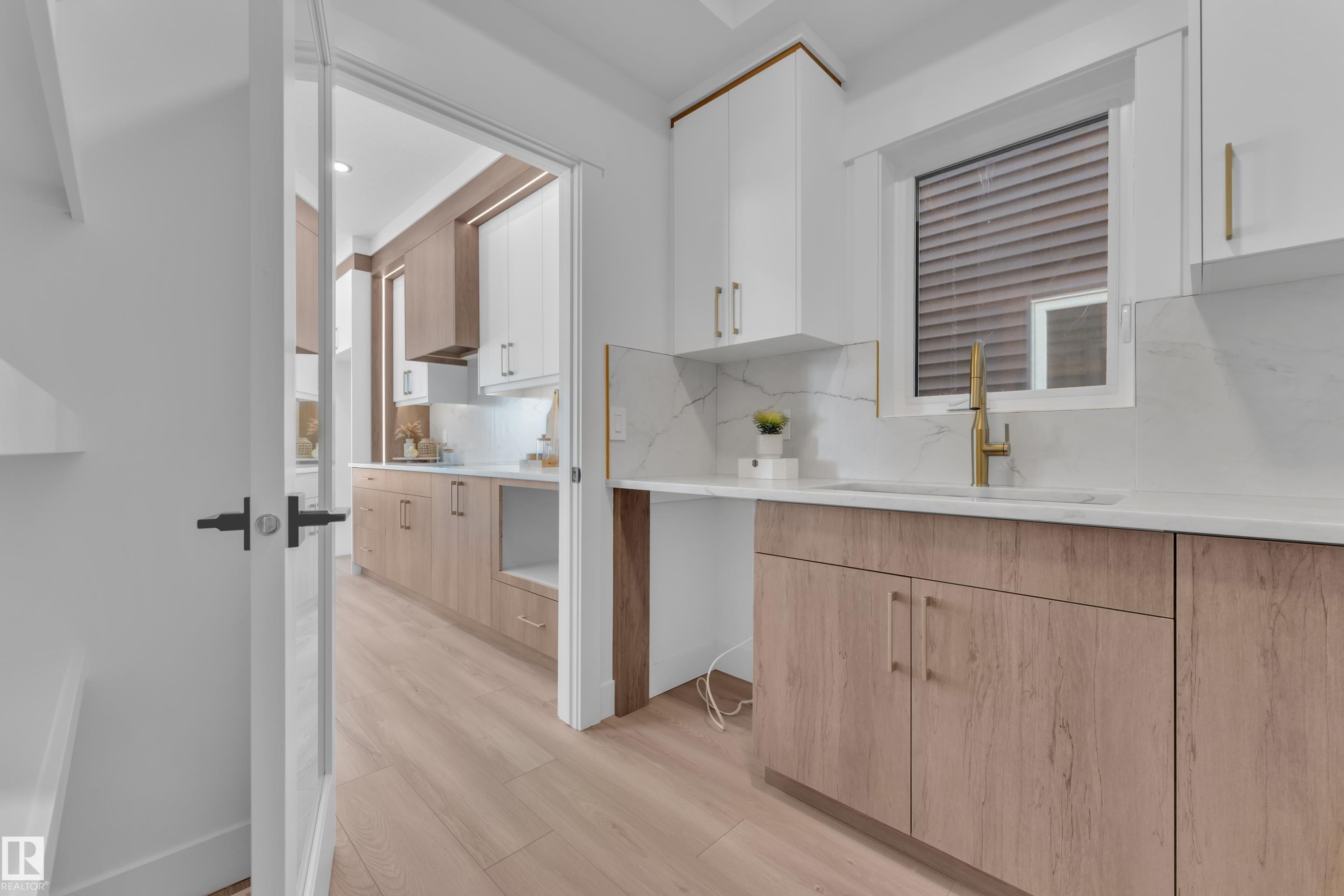 Kitchen with light wood finished floors, decorative backsplash, two tone color scheme, light stone countertops, and recessed lighting - 228 Linden Loop, Leduc, AB - Indoor Photo Showing Kitchen