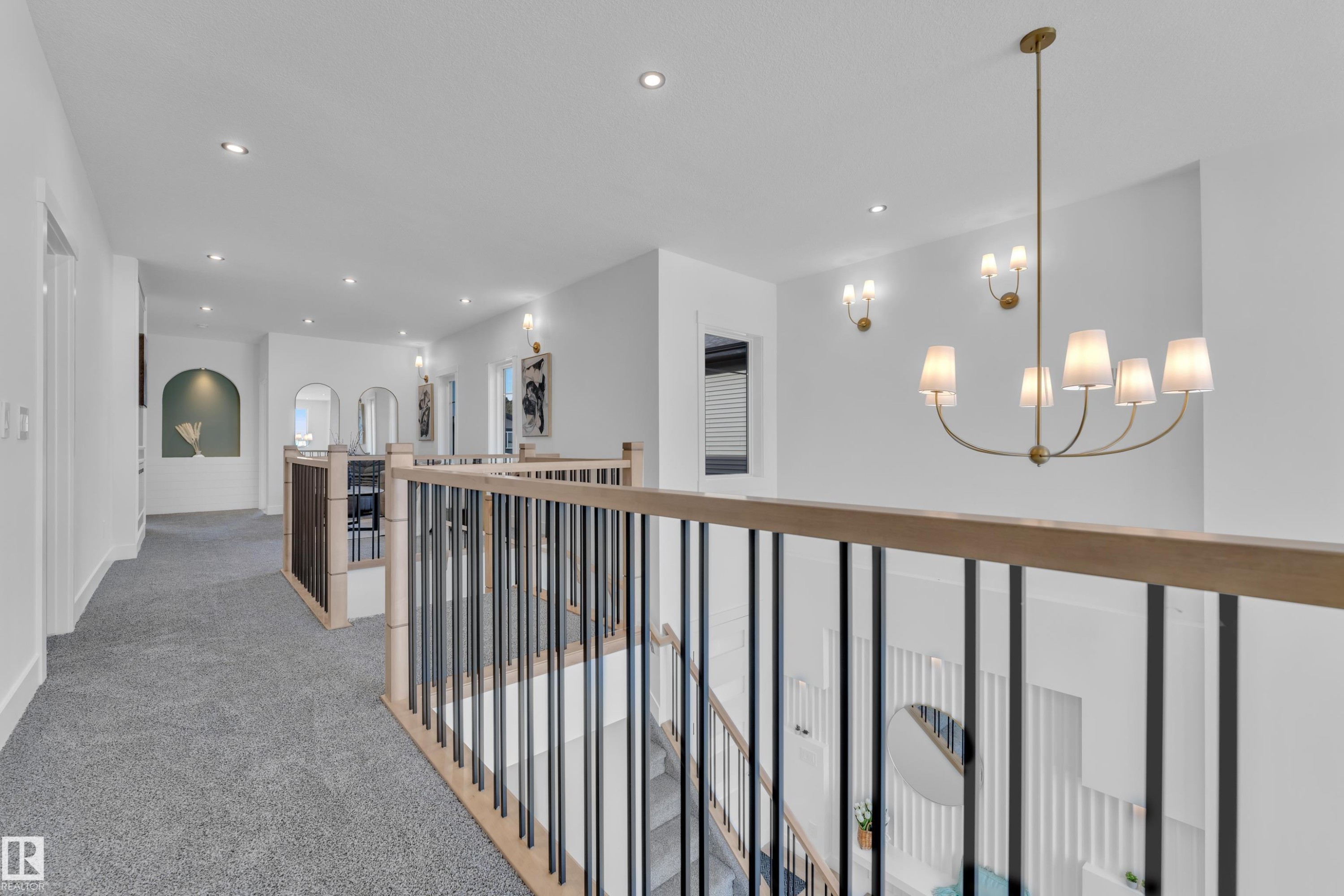 Corridor with light colored carpet, suspended lighting, and arched walkways - 228 Linden Loop, Leduc, AB - Indoor Photo Showing Other Room