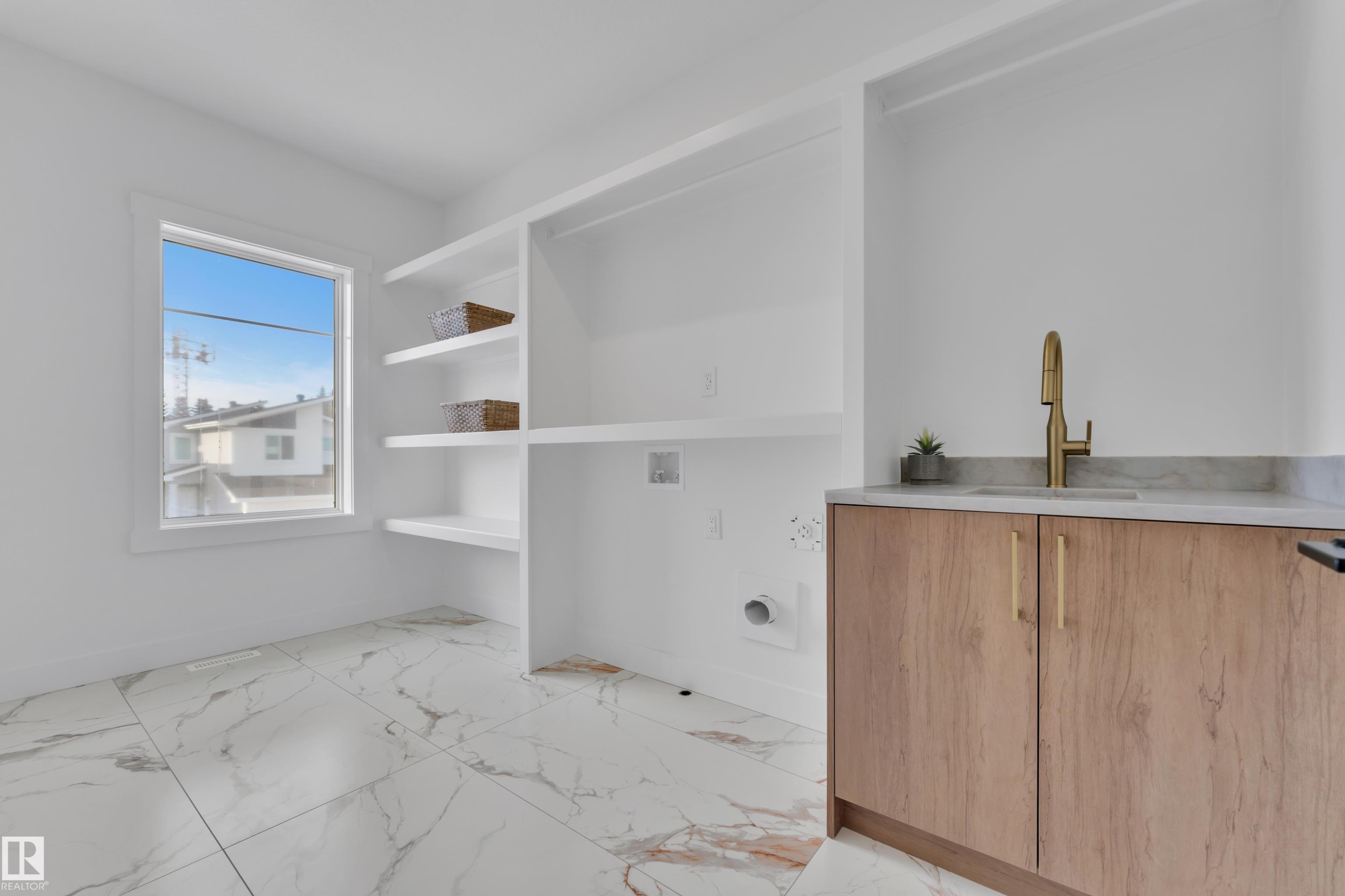 Laundry room featuring washer hookup and light marble finish flooring - 228 Linden Loop, Leduc, AB - Indoor