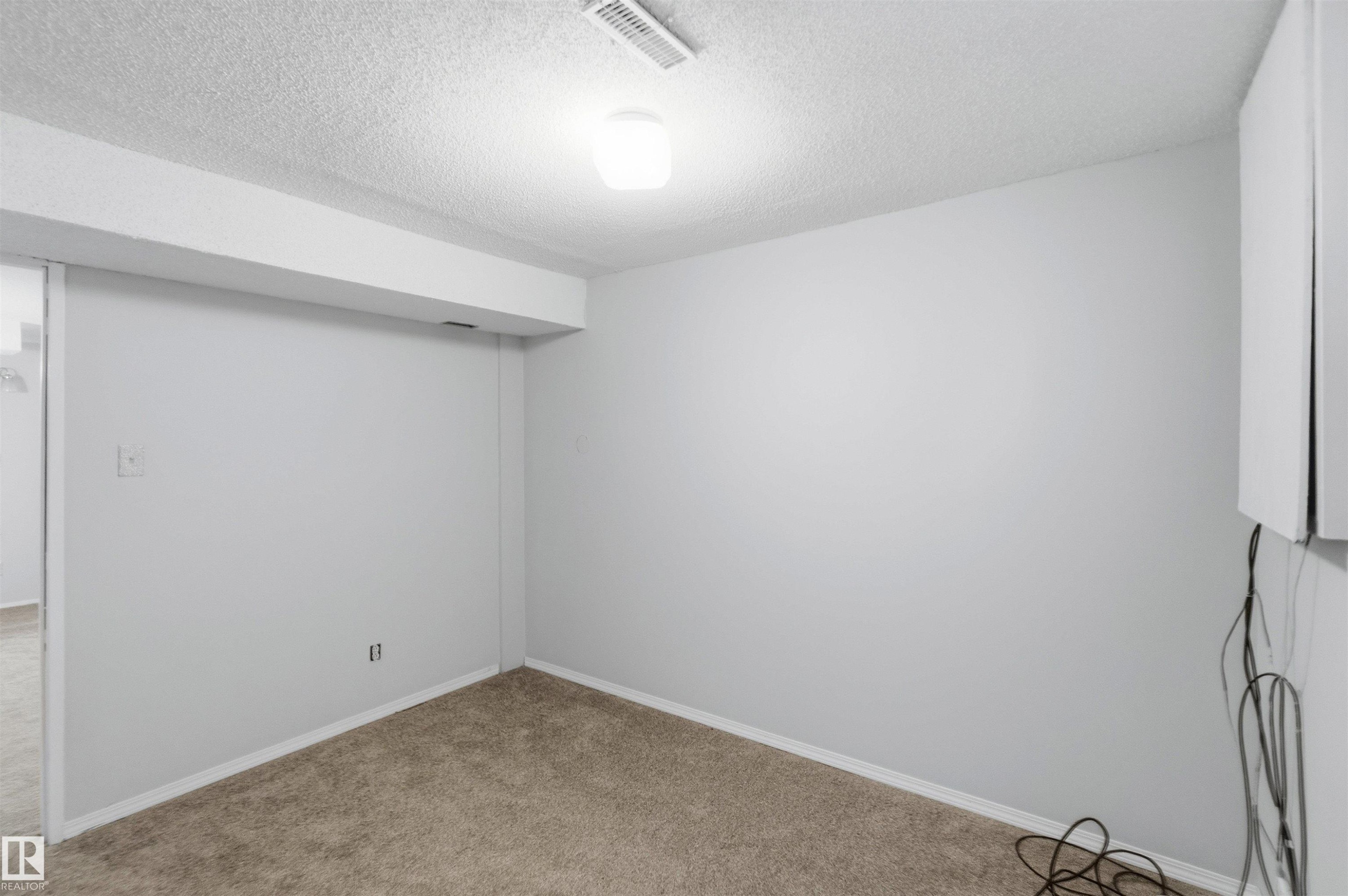 Spare room with a textured ceiling and carpet - 135 Humberstone Road, Edmonton, AB - Indoor Photo Showing Other Room
