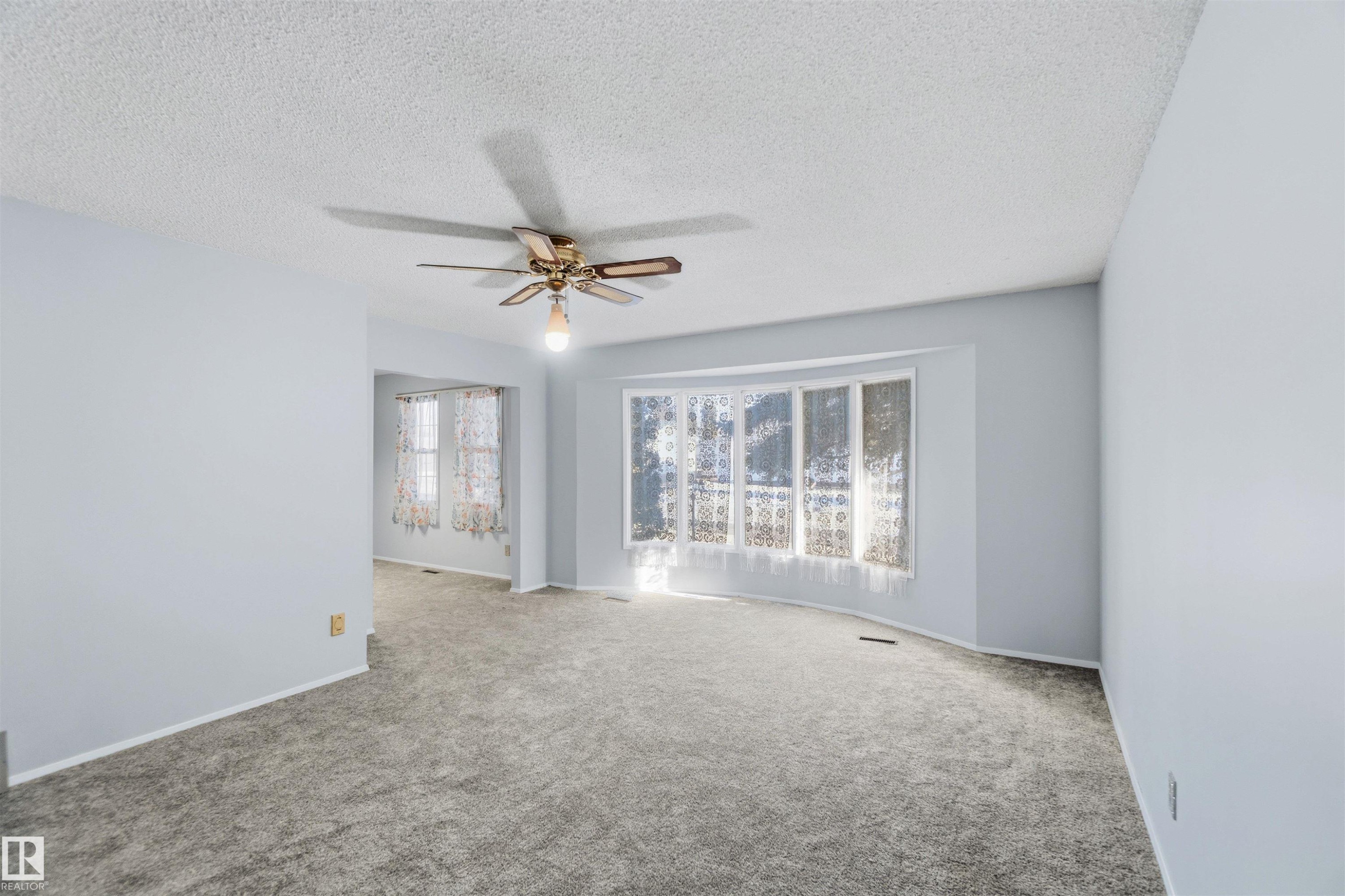 Carpeted empty room featuring ceiling fan and a textured ceiling - 135 Humberstone Road, Edmonton, AB - Indoor Photo Showing Other Room
