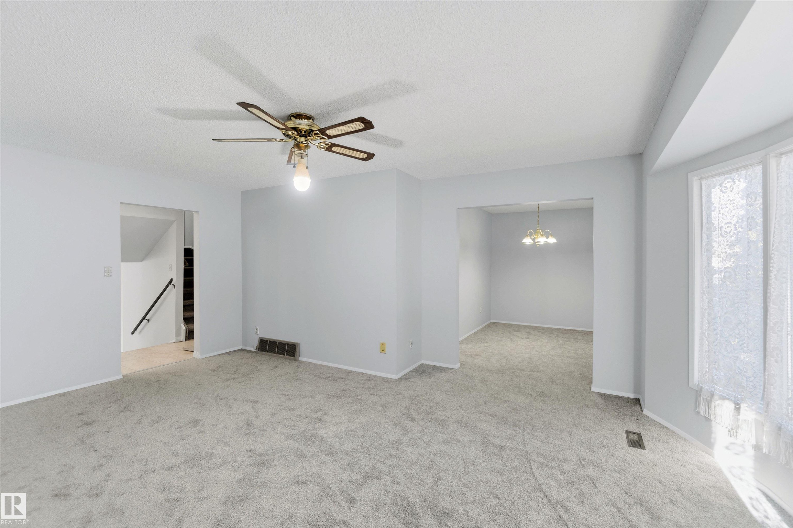 Spare room featuring a ceiling fan, light carpet, and hanging lights - 135 Humberstone Road, Edmonton, AB - Indoor Photo Showing Other Room