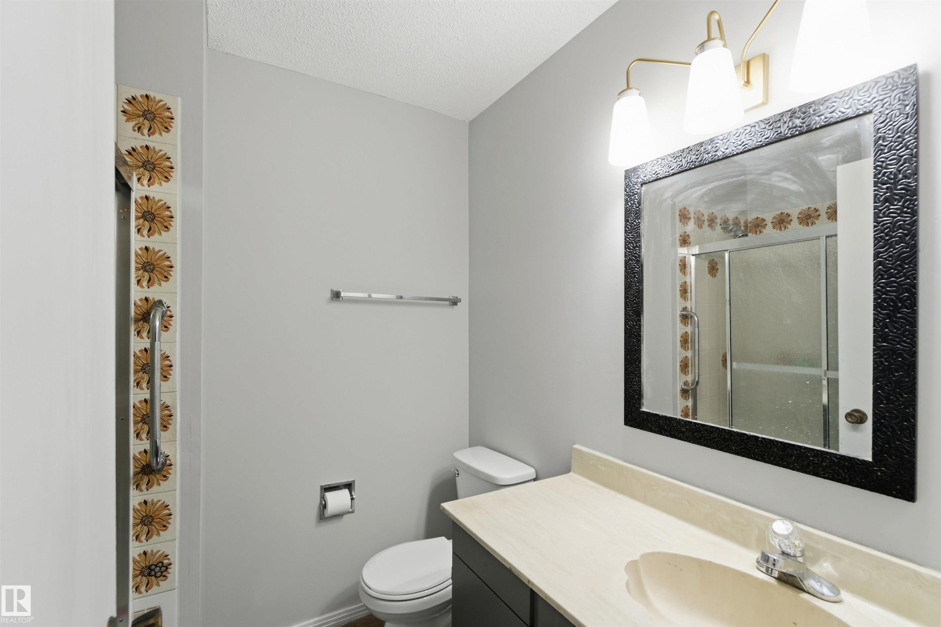 Full bath featuring a stall shower, vanity, and a textured ceiling - 135 Humberstone Road, Edmonton, AB - Indoor Photo Showing Bathroom