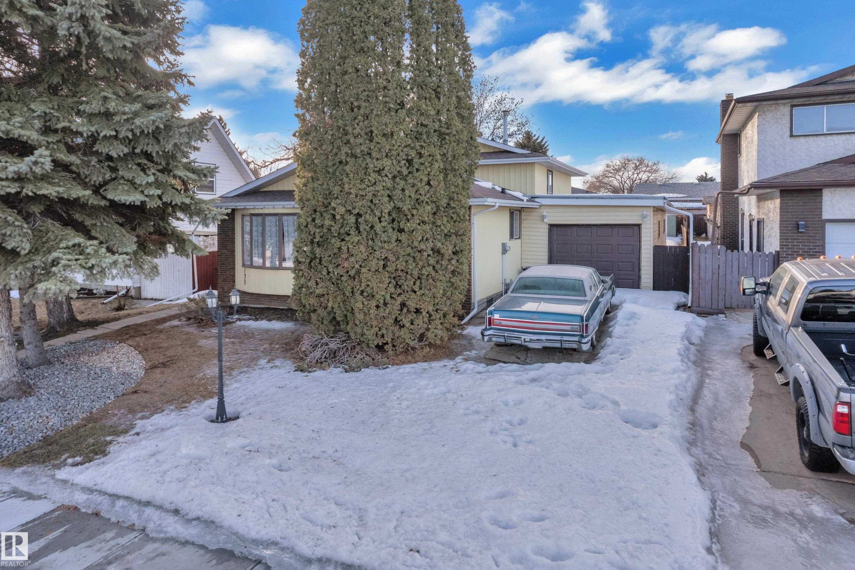 Obstructed view of property featuring a garage and brick siding - 135 Humberstone Road, Edmonton, AB - Outdoor