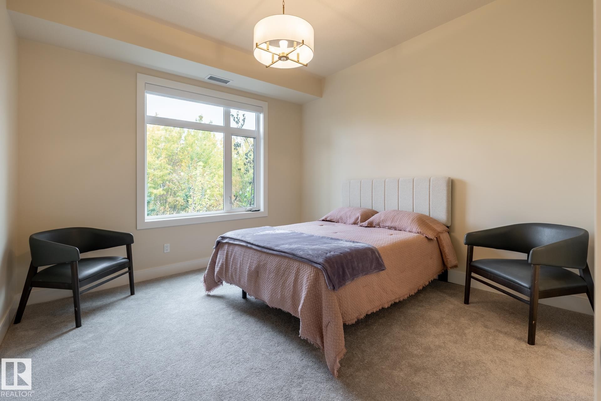 Bedroom with carpet and a chandelier - 112 7471 May Common, Edmonton, AB - Indoor Photo Showing Bedroom