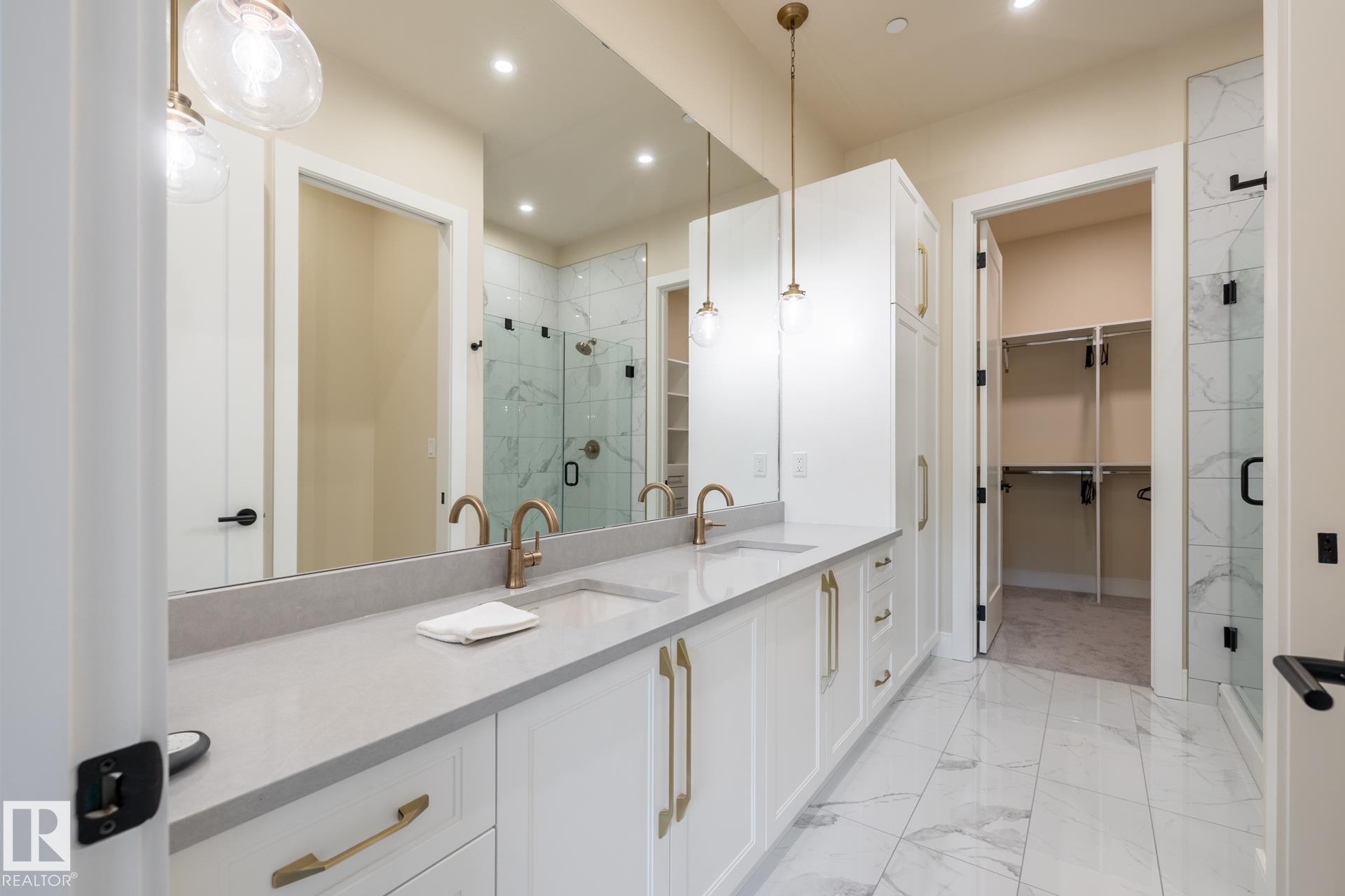 Full bathroom featuring double vanity, a shower stall, light marble finish flooring, recessed lighting, and a spacious closet - 112 7471 May Common, Edmonton, AB - Indoor Photo Showing Bathroom