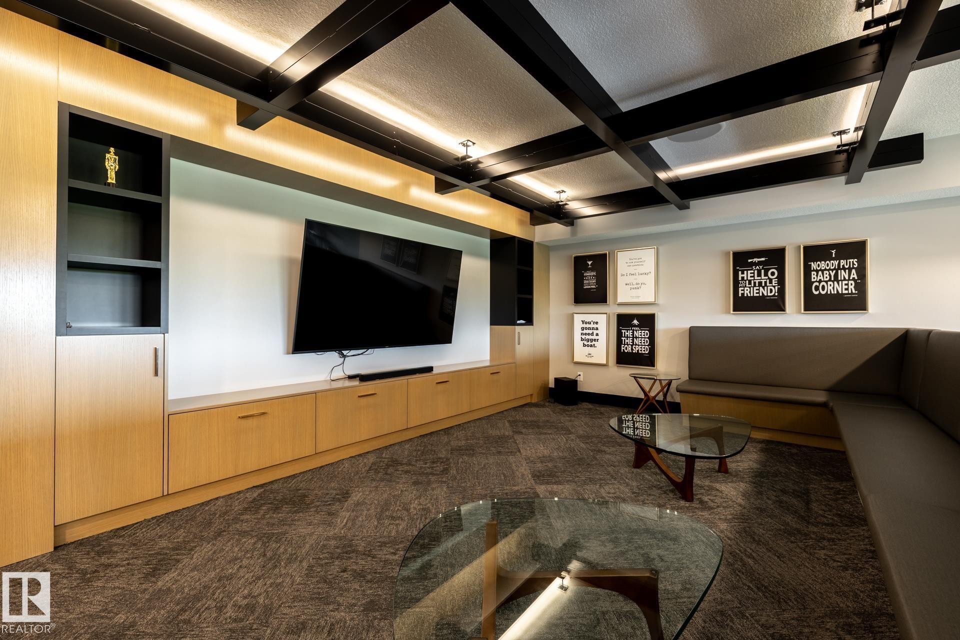 Home theater featuring a textured ceiling, dark carpet, beam ceiling, and coffered ceiling - 112 7471 May Common, Edmonton, AB - Indoor