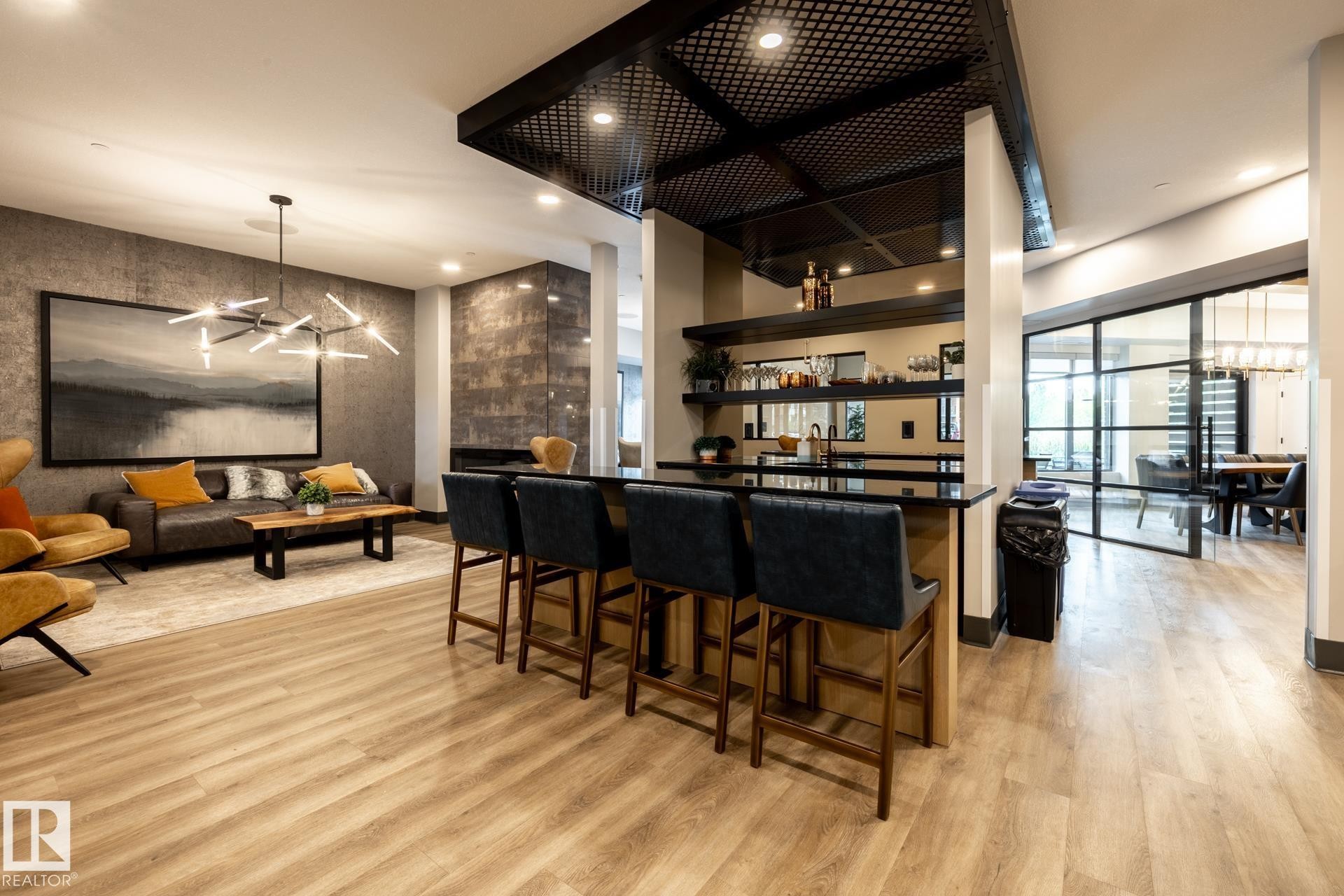 Kitchen featuring a chandelier, open shelves, dark countertops, hanging light fixtures, and recessed lighting - 112 7471 May Common, Edmonton, AB - Indoor Photo Showing Other Room