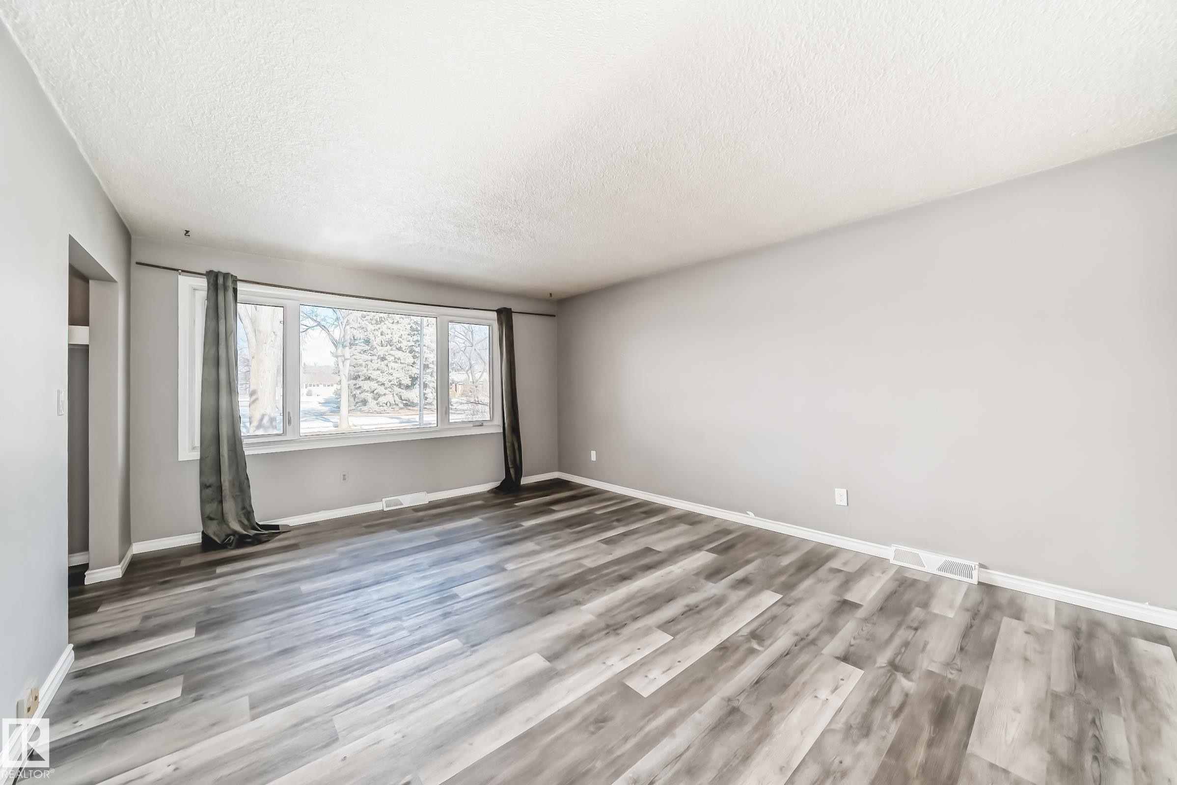 Unfurnished bedroom with light wood-style flooring and a textured ceiling - 8639 64 Avenue Nw, Edmonton, AB - Indoor Photo Showing Other Room