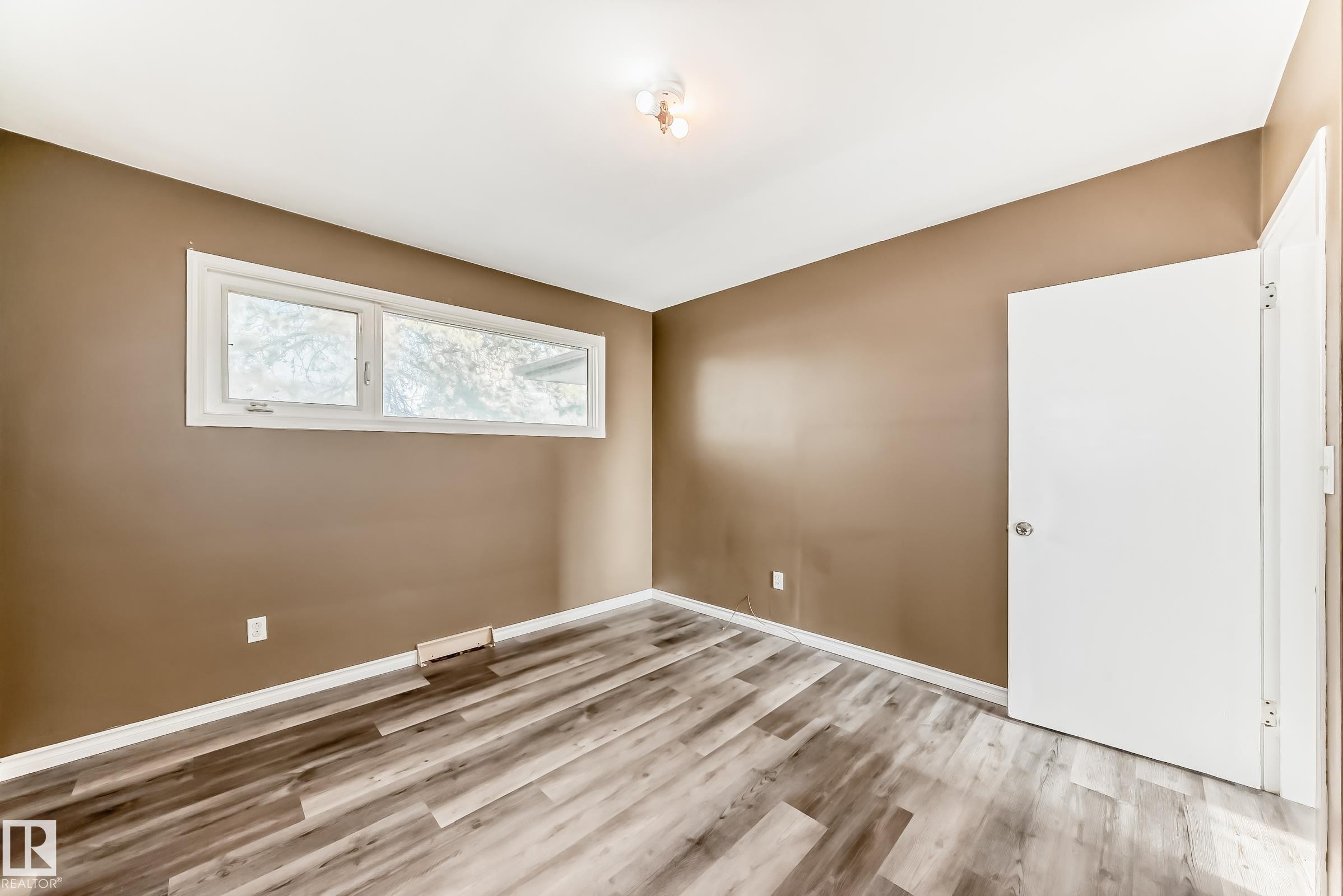 Empty room featuring light wood-style flooring and baseboards - 8639 64 Avenue Nw, Edmonton, AB - Indoor Photo Showing Other Room