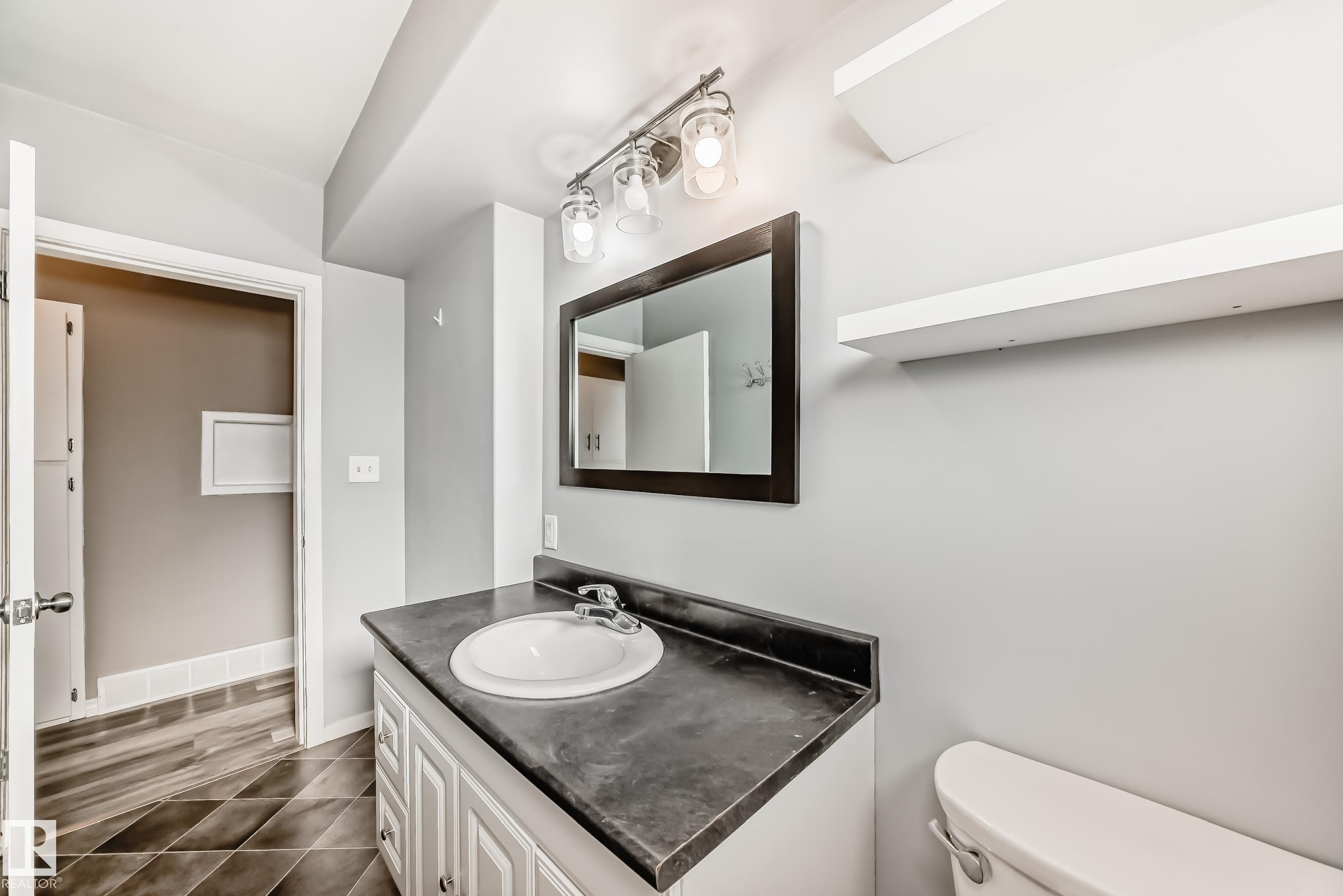 Bathroom with vanity and dark tile patterned flooring - 8639 64 Avenue Nw, Edmonton, AB - Indoor Photo Showing Bathroom