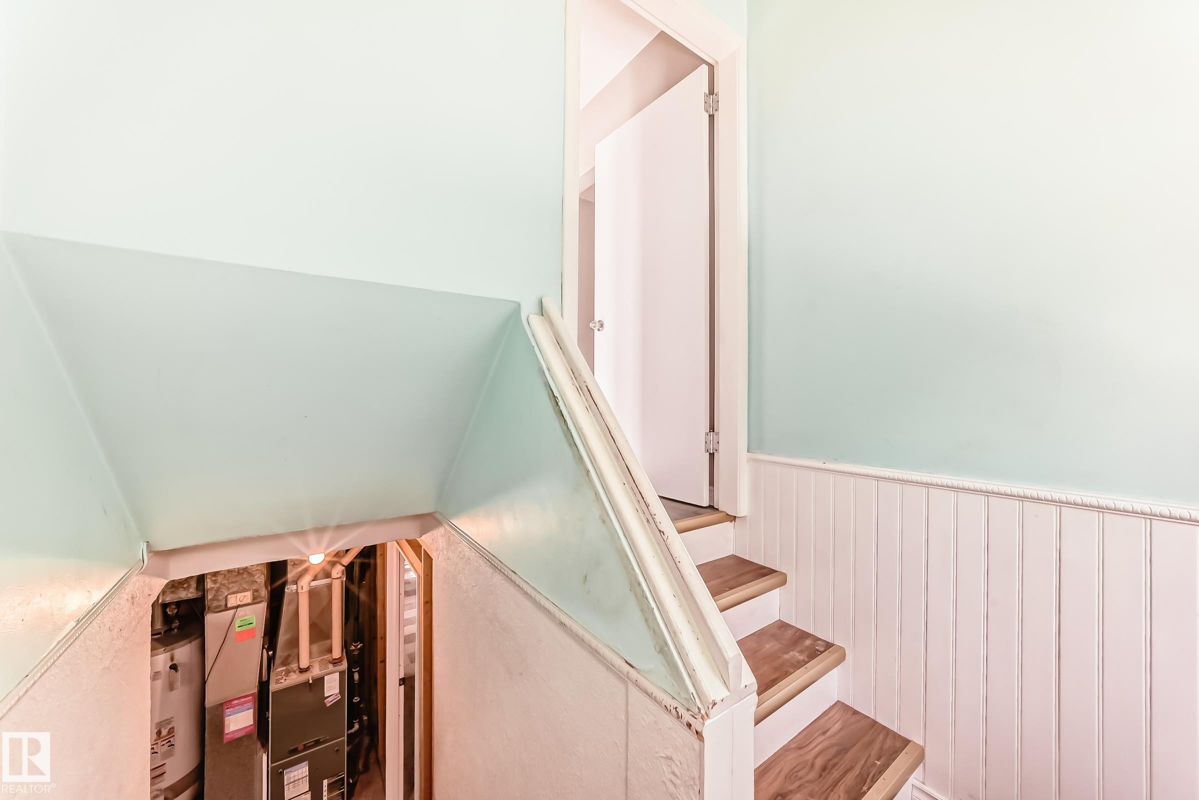 Staircase featuring a wainscoted wall and heating unit - 8639 64 Avenue Nw, Edmonton, AB - Indoor Photo Showing Other Room