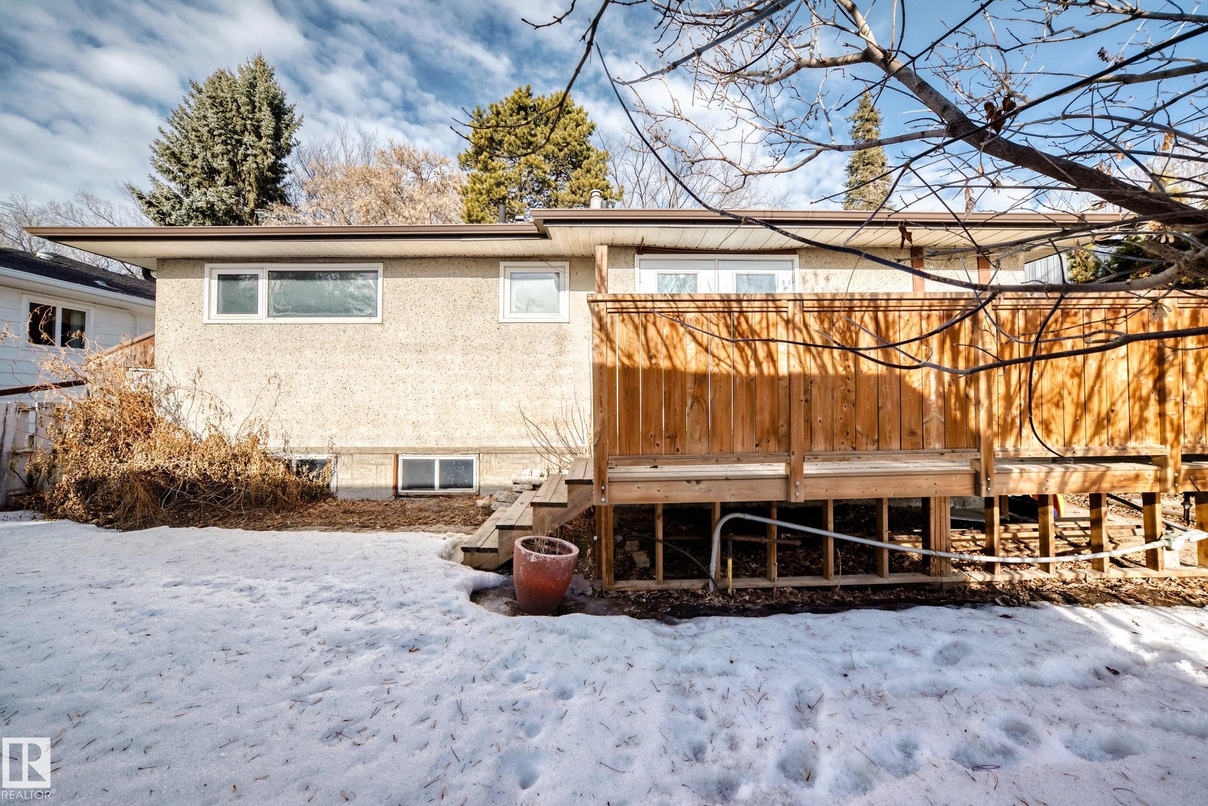 Snow covered property with stucco siding and stairs - 8639 64 Avenue Nw, Edmonton, AB - Outdoor