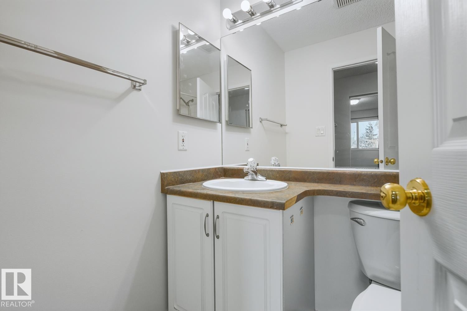 Bathroom featuring a vanity with a white basin sink, white cabinetry, and a brown countertop - 237 17447 98A Avenue, Edmonton, AB - Indoor Photo Showing Bathroom