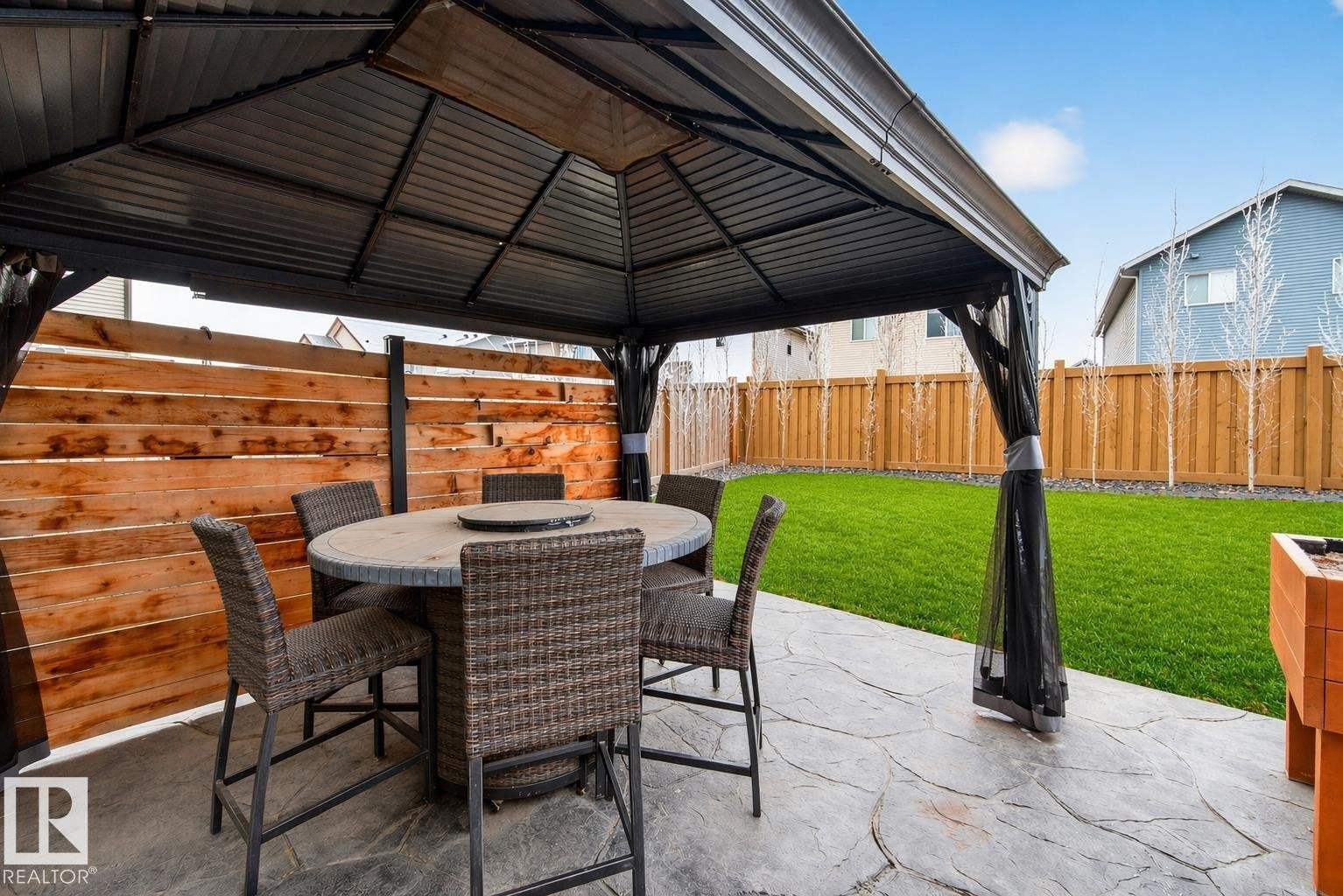 The property features a spacious patio area with a gazebo, a privacy fence, and a large lawn - 17838 60A Street, Edmonton, AB - Outdoor With Deck Patio Veranda