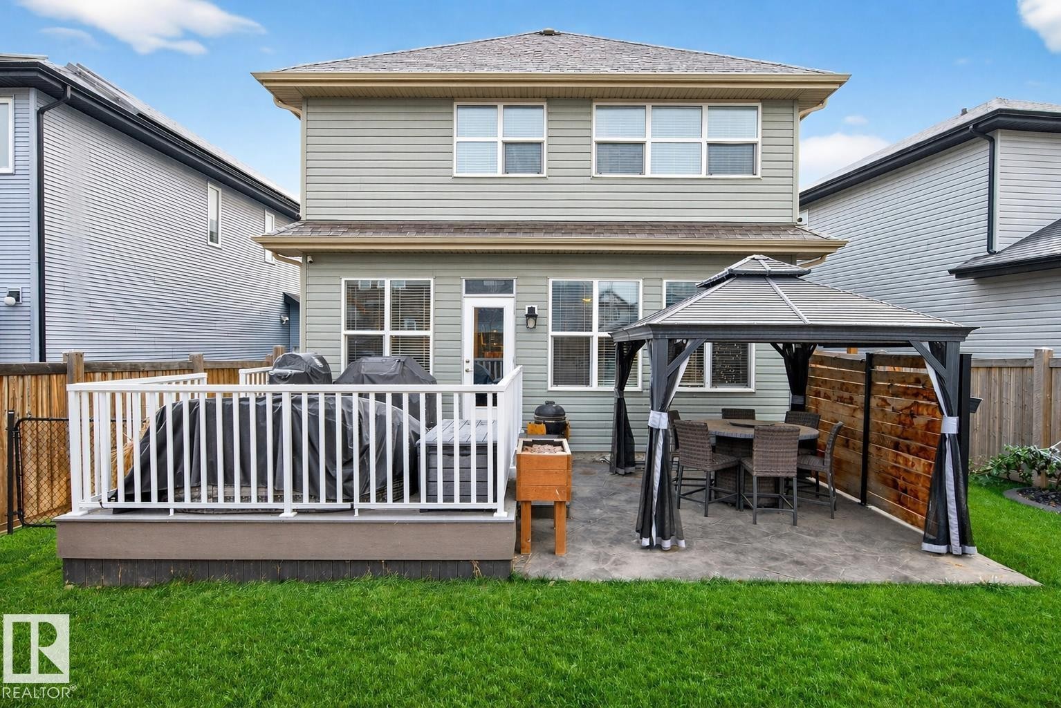 The property features a well-maintained lawn and a private backyard with a deck - 17838 60A Street, Edmonton, AB - Outdoor With Deck Patio Veranda With Exterior