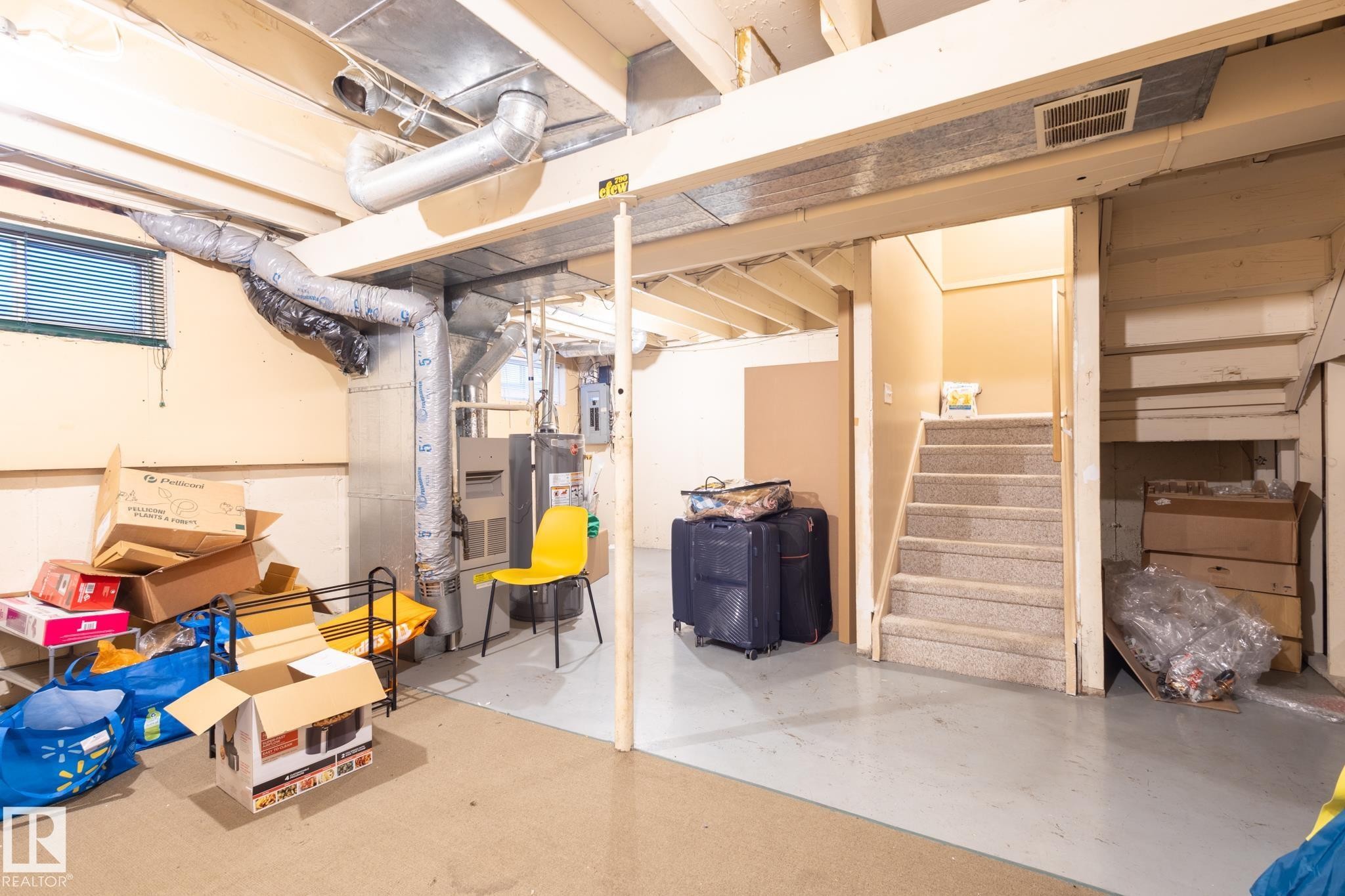 Unfinished below grade area featuring gas water heater, stairs, heating unit, and electric panel - 3530 42 Street, Edmonton, AB - Indoor Photo Showing Basement