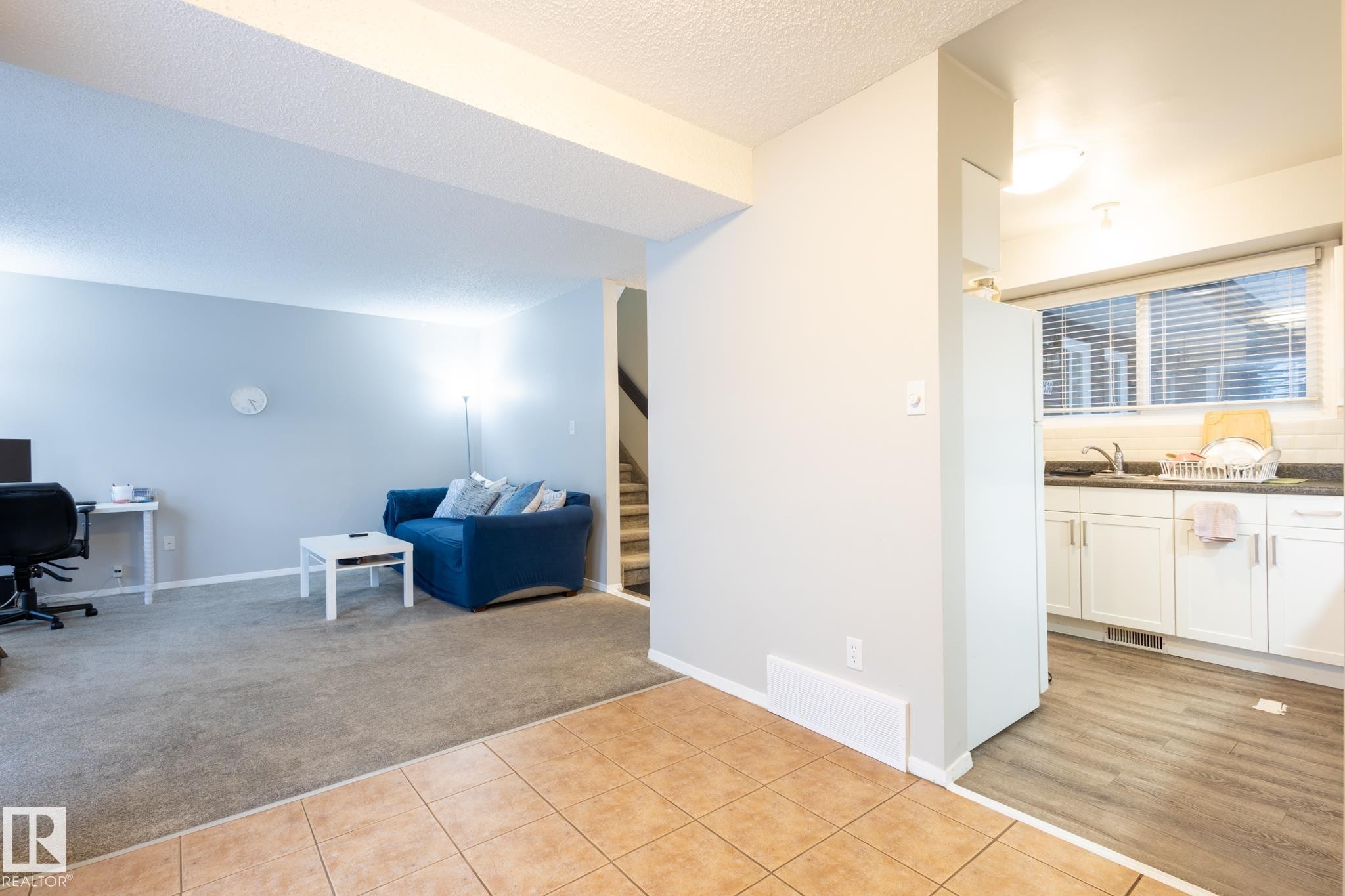 Office featuring light tile patterned floors, light colored carpet, and a textured ceiling - 3530 42 Street, Edmonton, AB - Indoor
