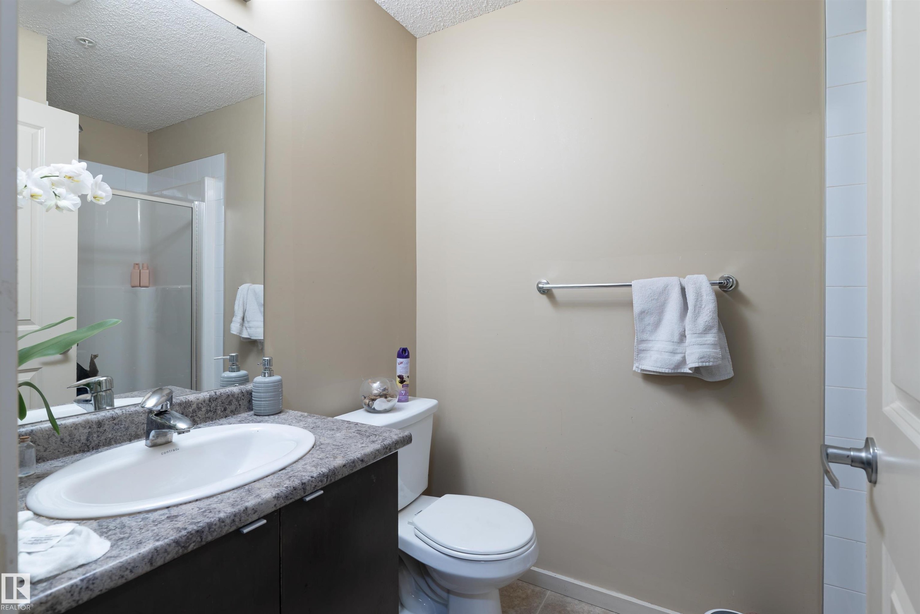Bathroom featuring a shower stall, vanity, and a textured ceiling - 211 340 Windermere Road, Edmonton, AB - Indoor Photo Showing Bathroom