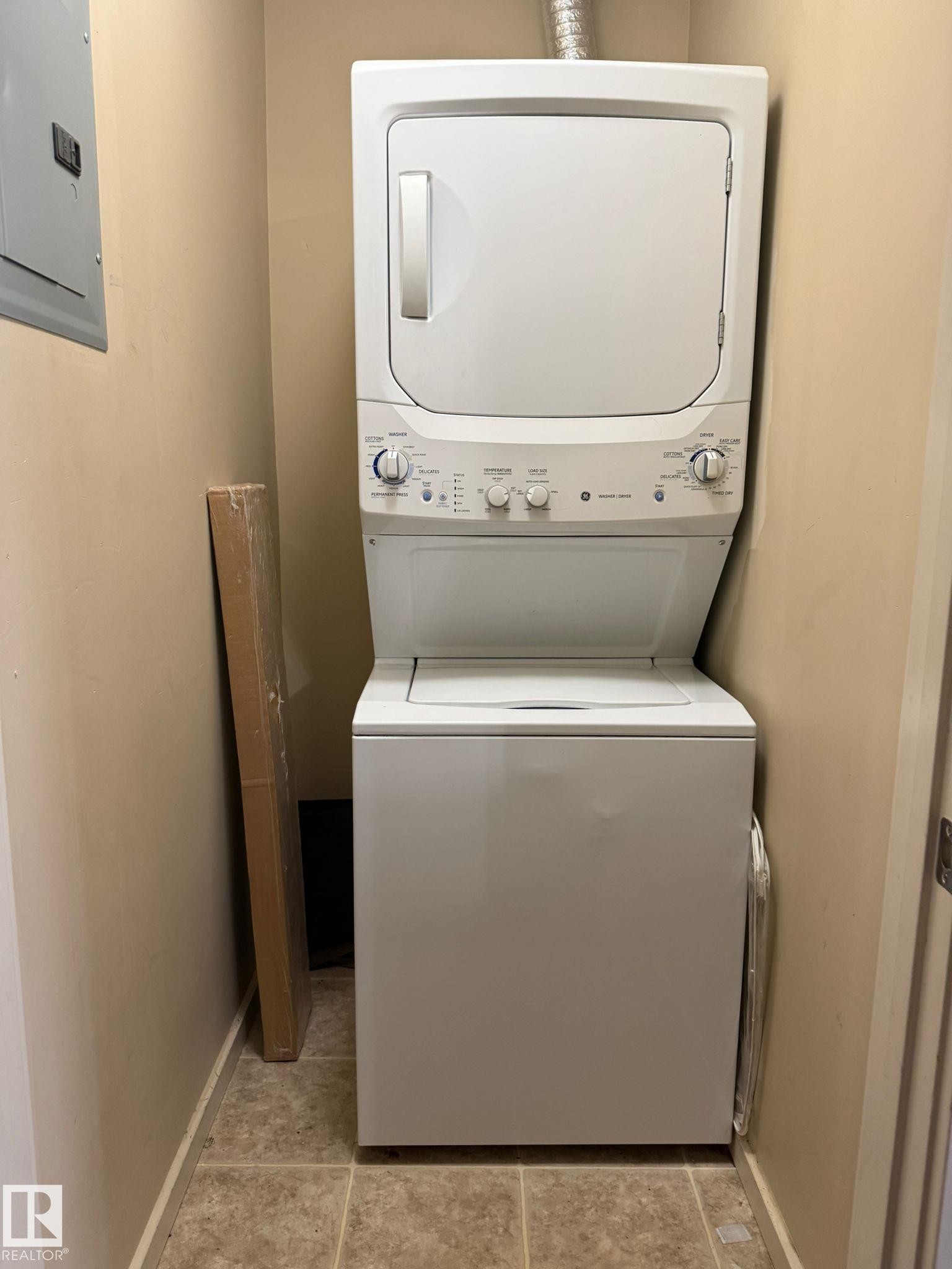 Laundry area with stacked washing machine and dryer and electric panel - 211 340 Windermere Road, Edmonton, AB - Indoor Photo Showing Laundry Room