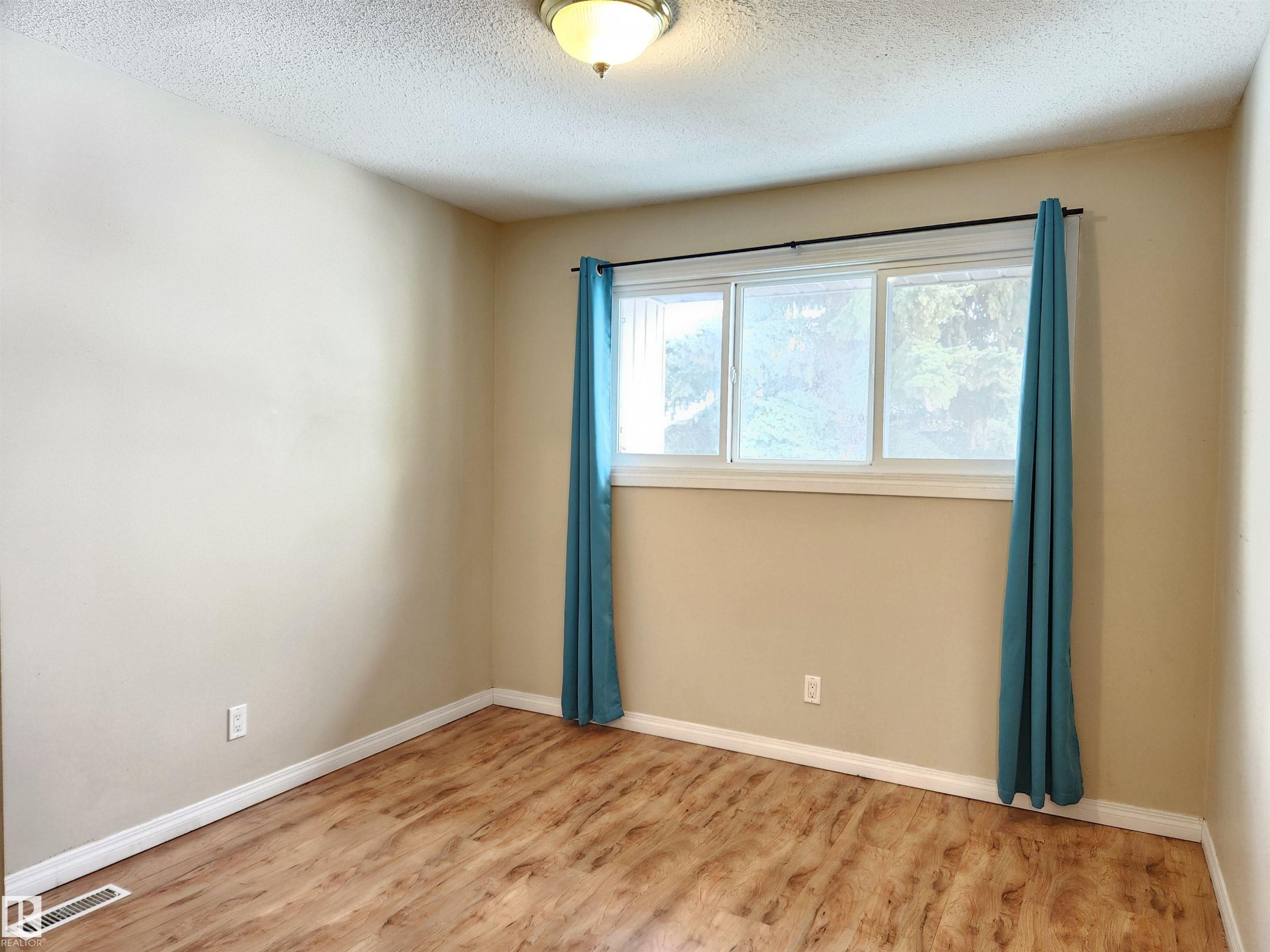 Unfurnished room with light wood-type flooring and a textured ceiling - 6 14320 80 Street, Edmonton, AB - Indoor Photo Showing Other Room