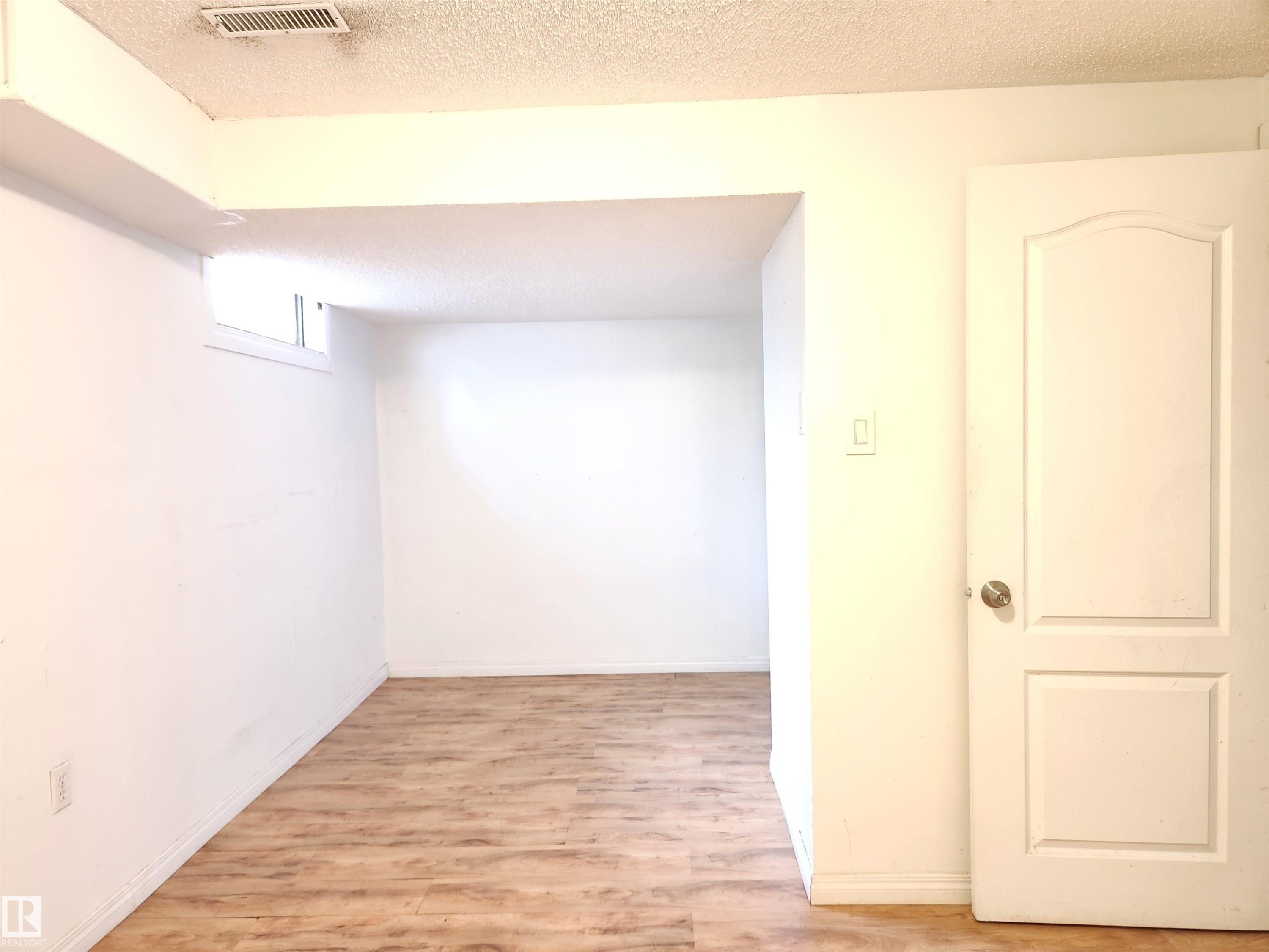 Hallway with a textured ceiling and light wood finished floors - 6 14320 80 Street, Edmonton, AB - Indoor Photo Showing Other Room