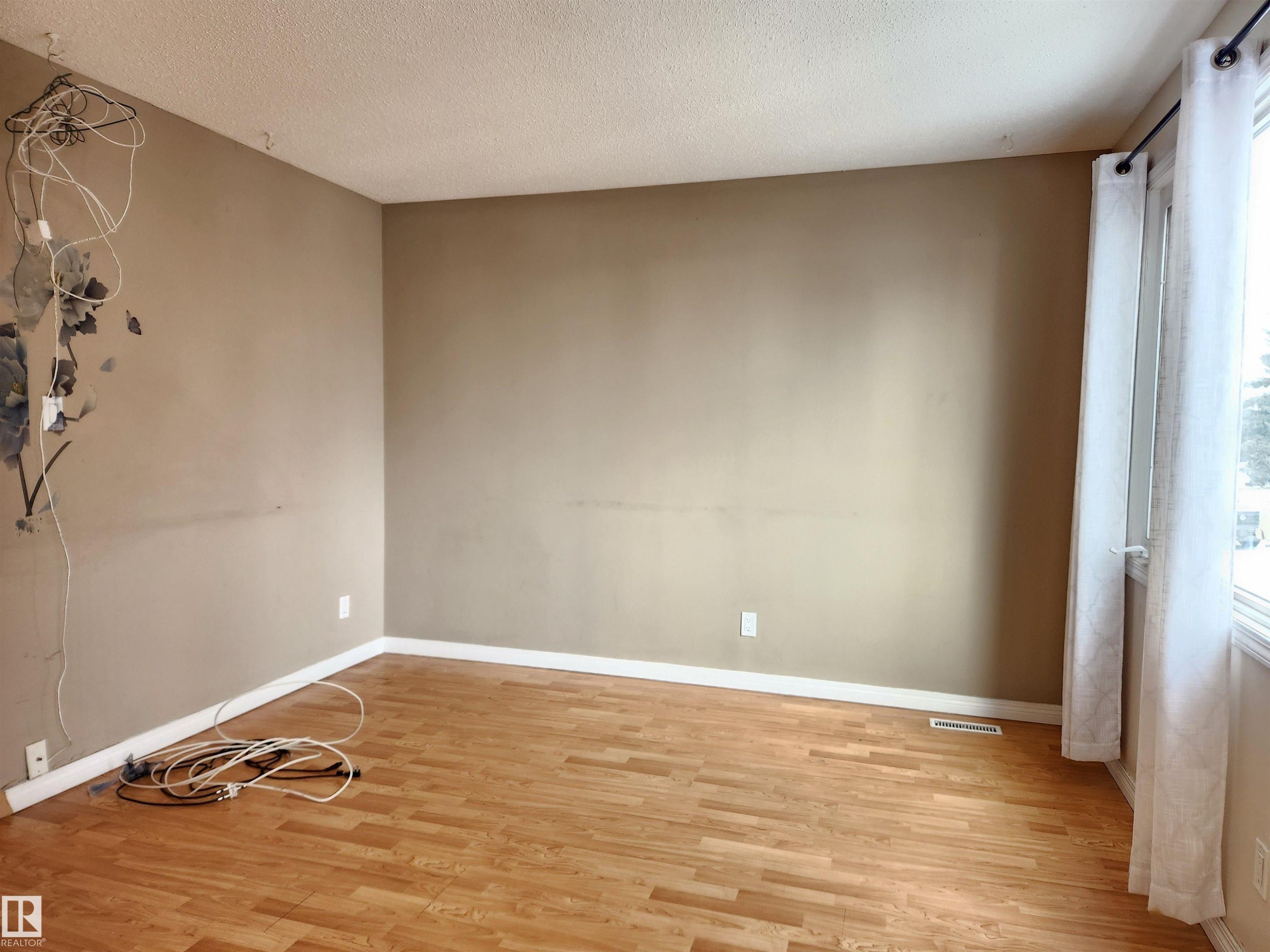 Unfurnished room with wood finished floors and a textured ceiling - 6 14320 80 Street, Edmonton, AB - Indoor Photo Showing Other Room