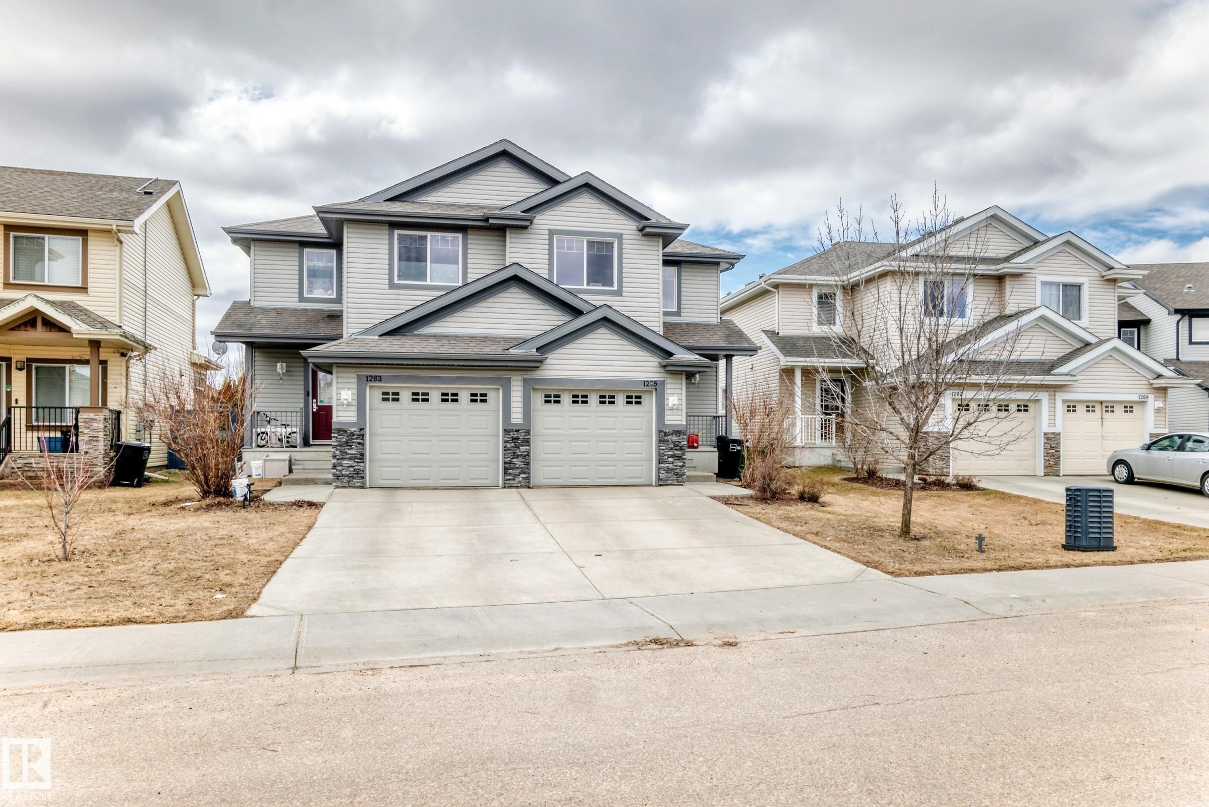 Two-story home with a light gray siding exterior, dark gray trim, and a dark gray roof - 1285 Cunningham Drive, Edmonton, AB - Outdoor With Facade