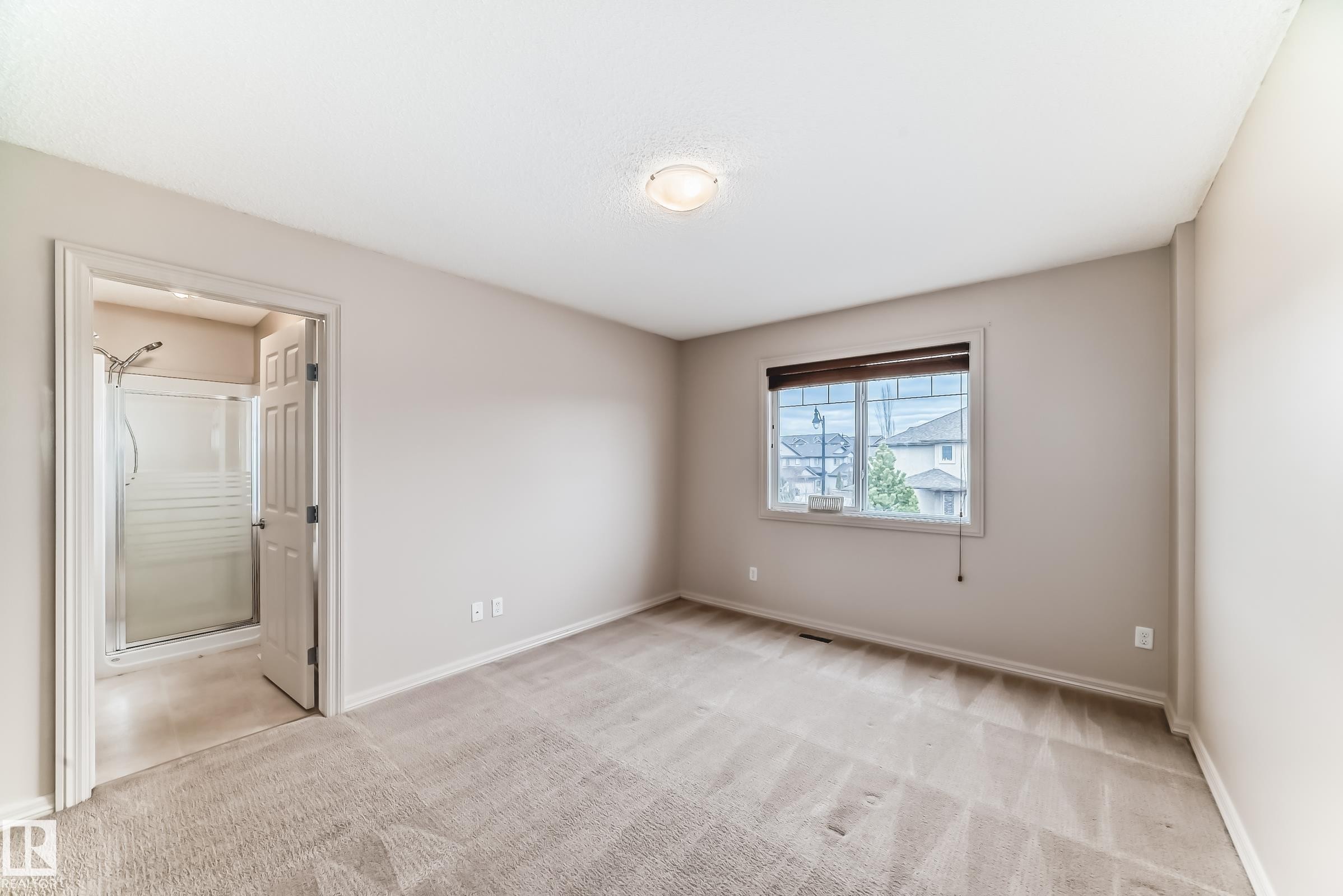 Spacious room featuring neutral carpet flooring, light-toned walls, and a window with blinds - 1285 Cunningham Drive, Edmonton, AB - Indoor Photo Showing Other Room