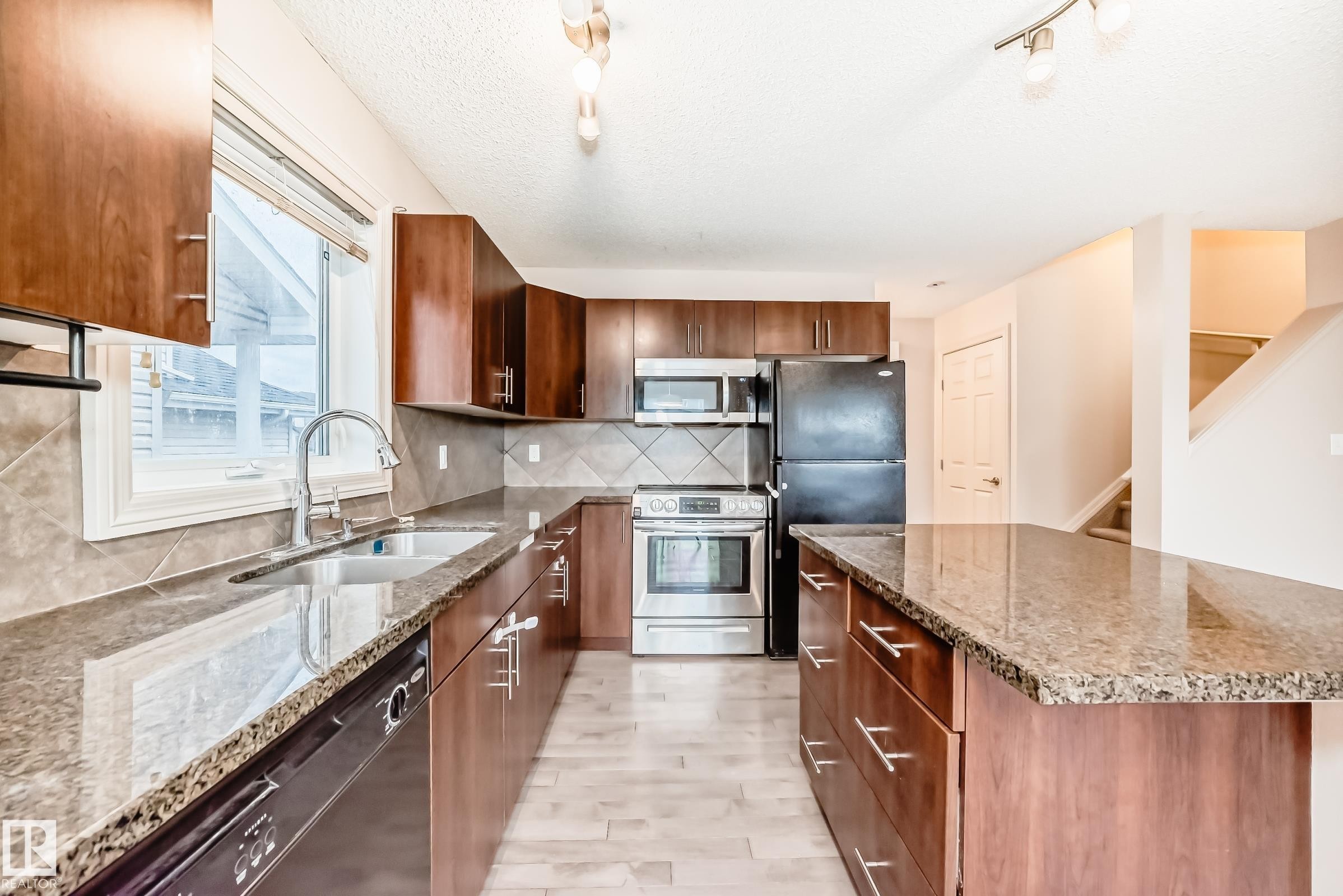 Kitchen featuring wood-finish cabinetry and granite countertops - 1285 Cunningham Drive, Edmonton, AB - Indoor Photo Showing Kitchen With Double Sink