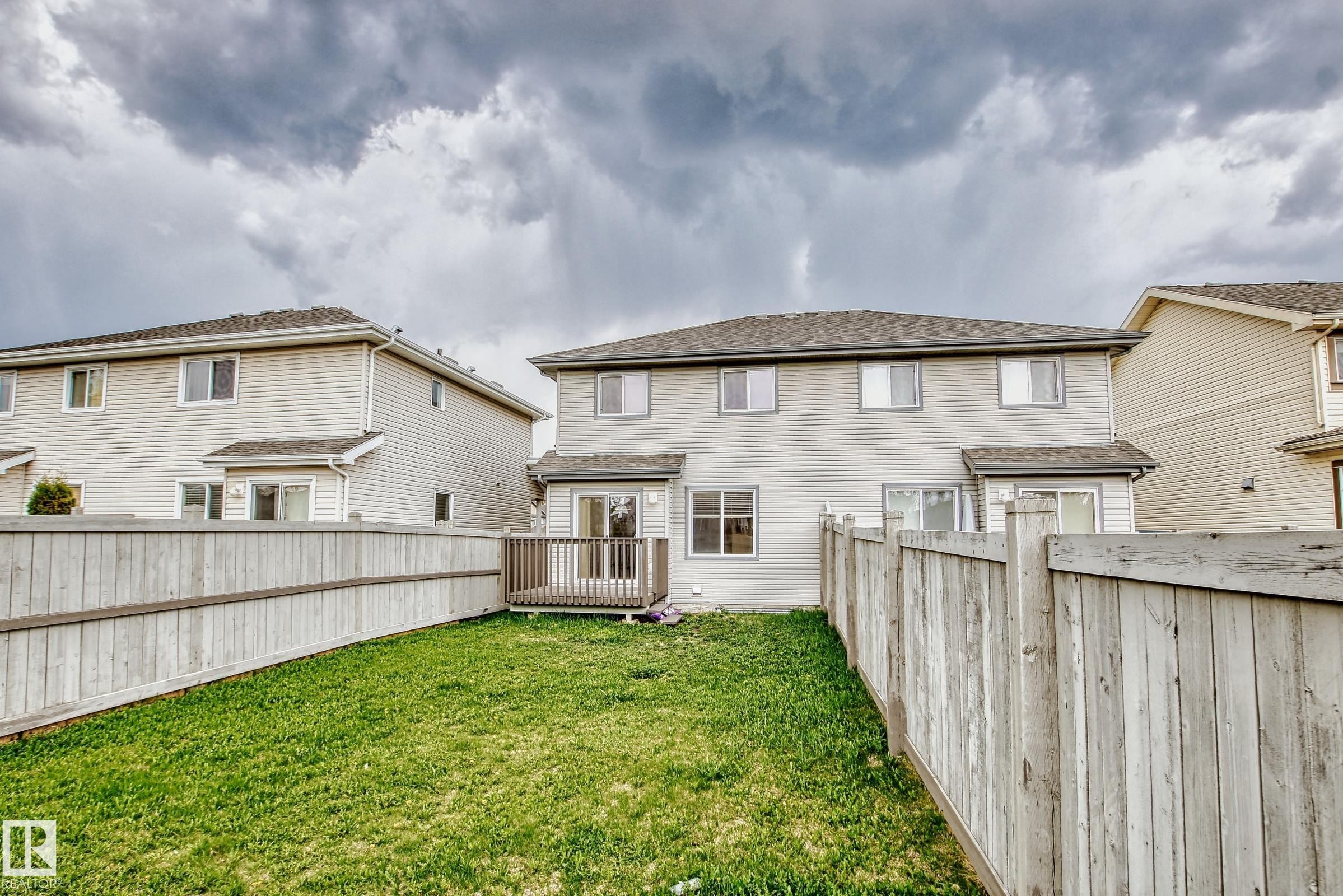 The property features a private backyard with a lawn and a wooden fence - 1285 Cunningham Drive, Edmonton, AB - Outdoor With Exterior