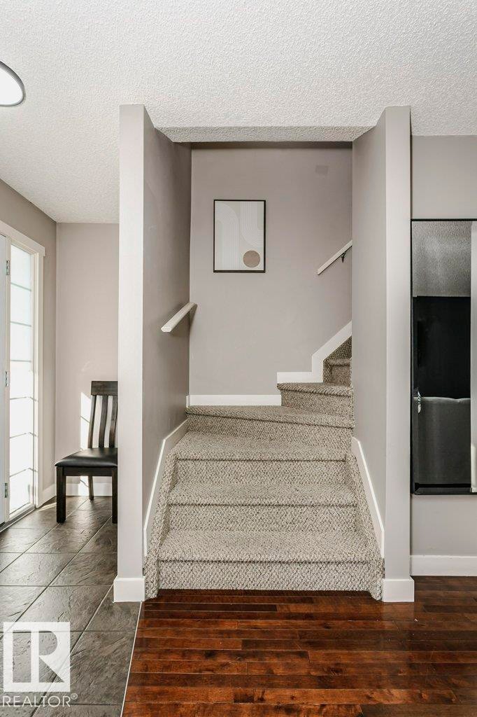 Stairs with a textured ceiling and wood finished floors - 1381 Rutherford Road, Edmonton, AB - Indoor Photo Showing Other Room