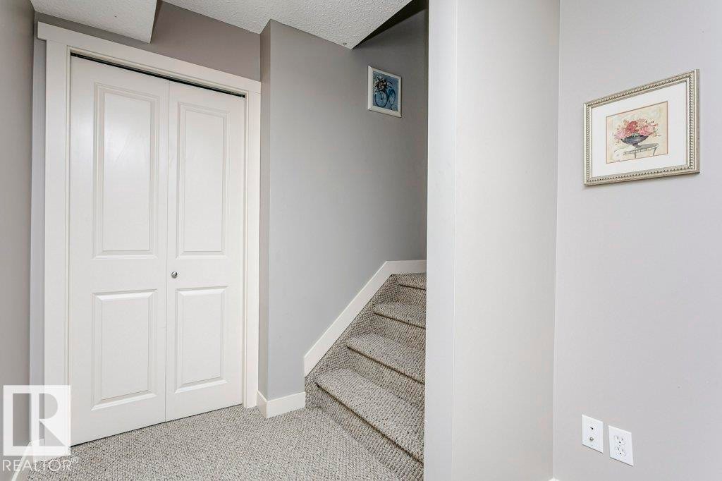 Stairs with carpet and a textured ceiling - 1381 Rutherford Road, Edmonton, AB - Indoor Photo Showing Other Room