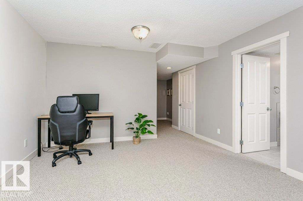 Office space featuring light colored carpet and a textured ceiling - 1381 Rutherford Road, Edmonton, AB - Indoor
